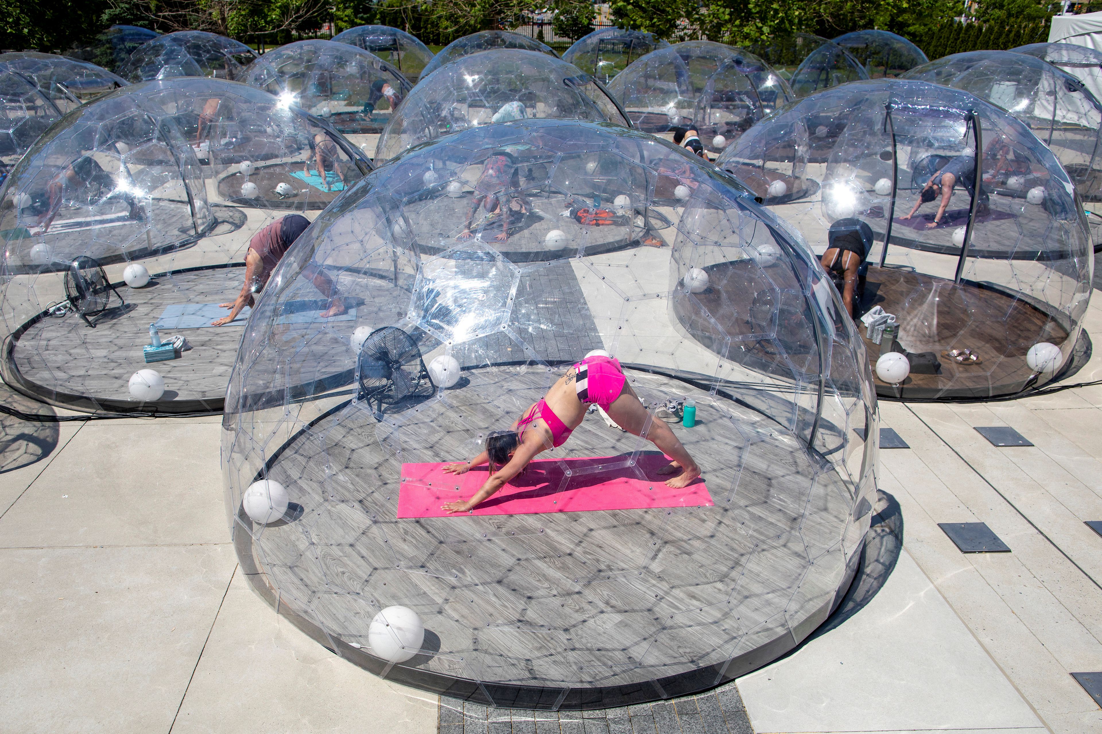 Un grupo de personas participa en una clase al aire libre en Toronto (Canadá) dentro de cúpulas para garantizar el distanciamiento social.