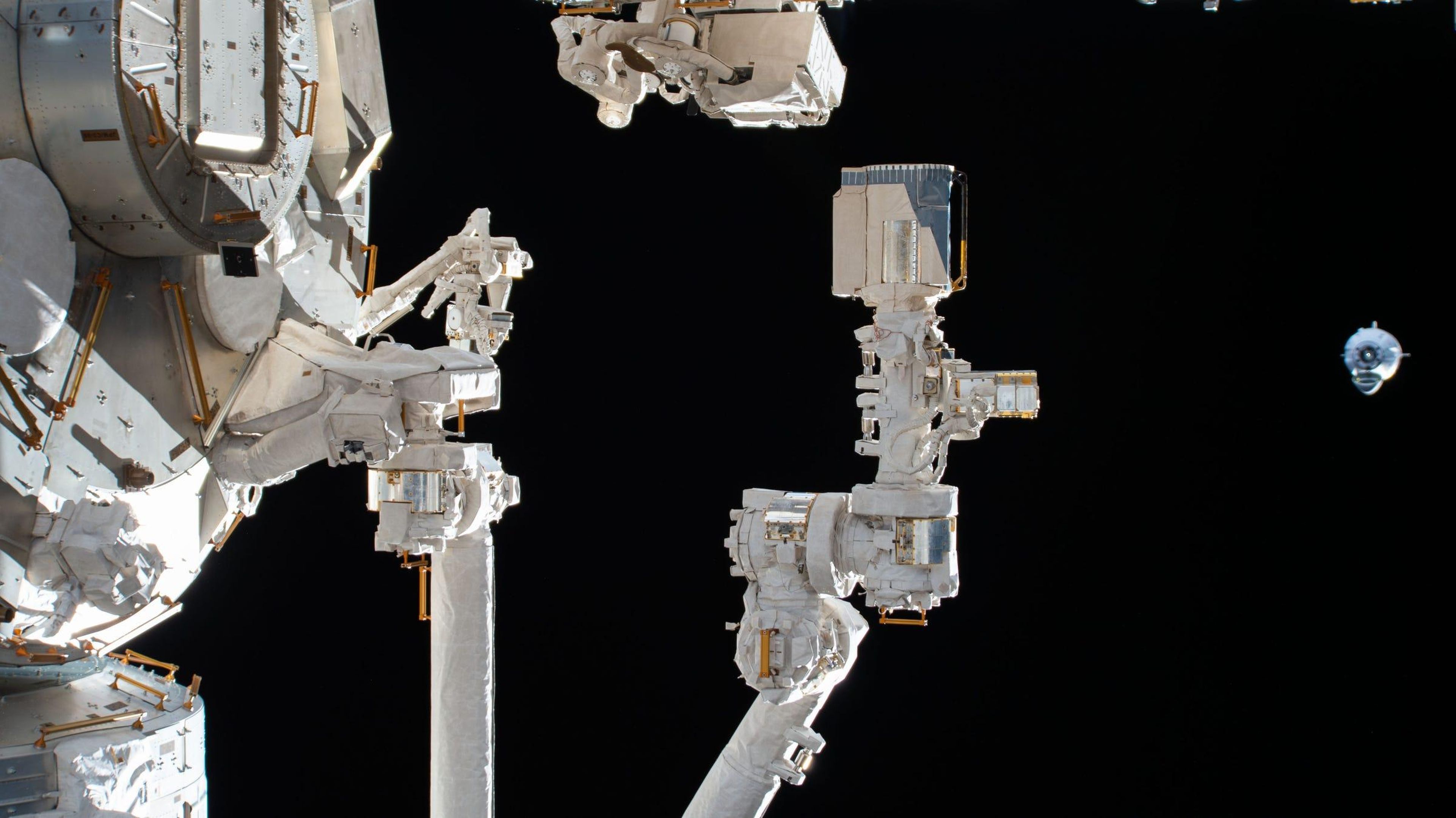 El SpaceX Crew Dragon (derecha) se acerca a la Estación Espacial Internacional. En primer plano está el brazo robótico conectado al módulo de laboratorio Kibo de la Agencia de Exploración Aeroespacial de Japón.