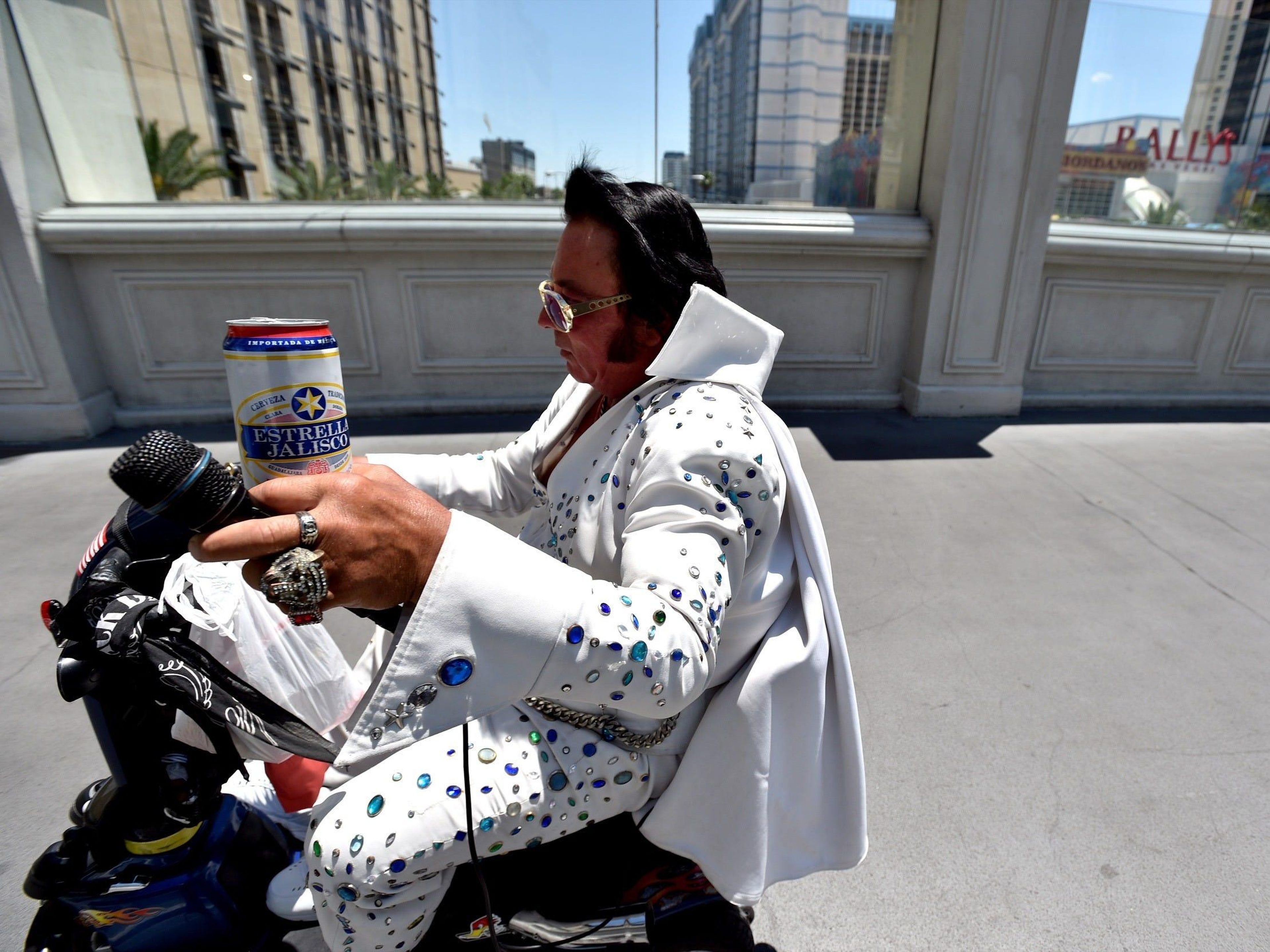 Un imitador de Elvis conduce su motocicleta por un puente peatonal en Las Vegas el 4 de junio de 2020.