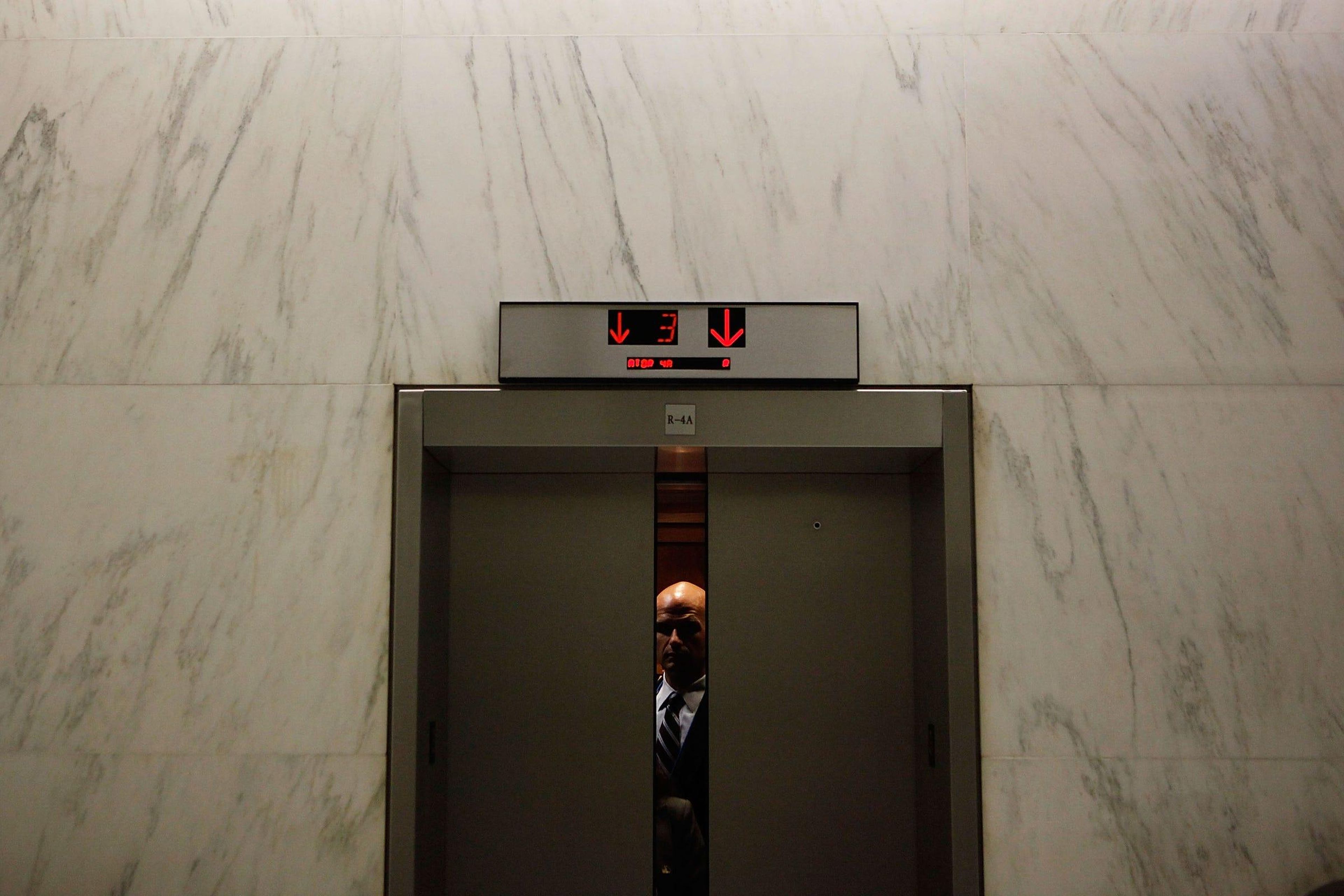 A man riding an office elevator.