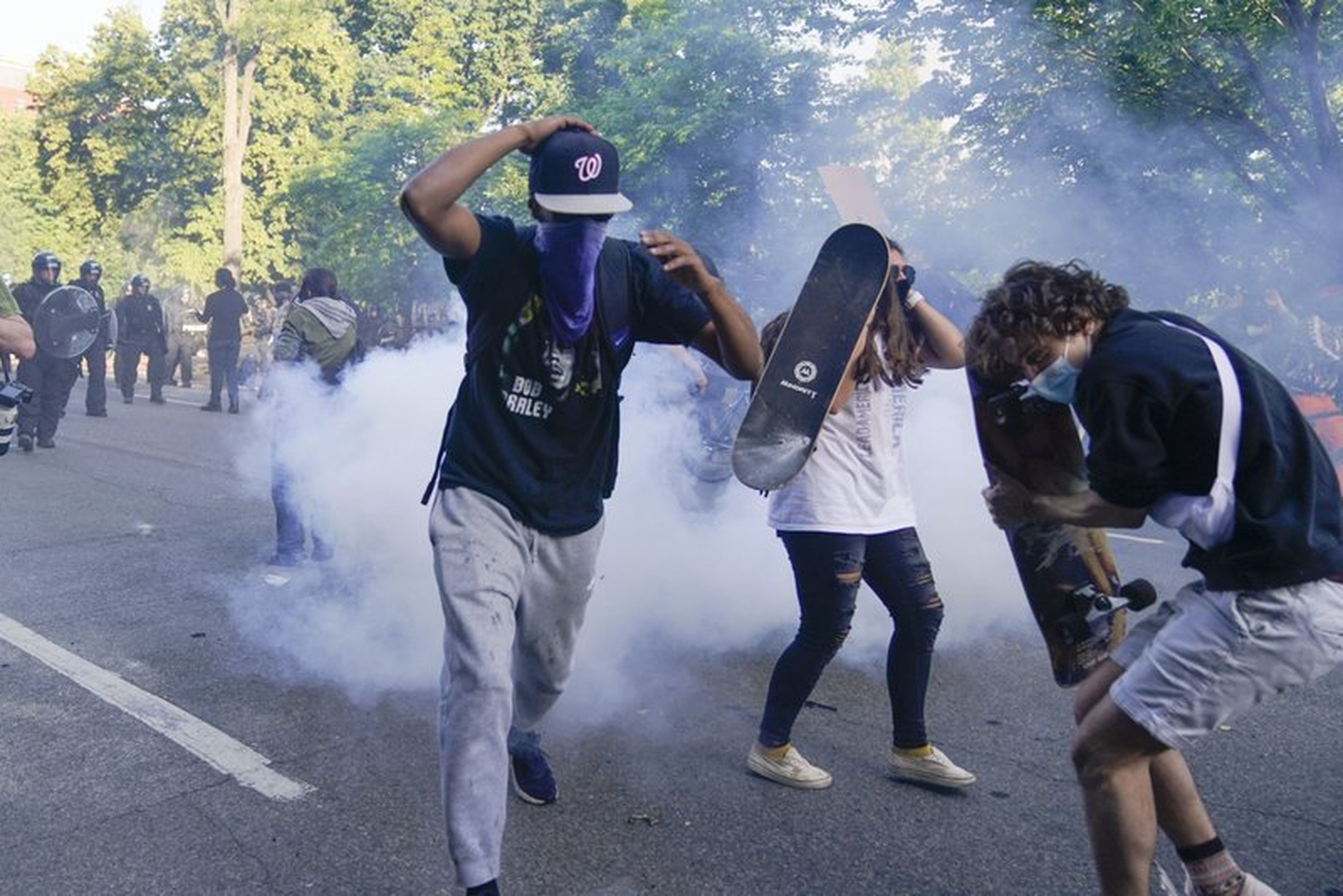 Los manifestantes, reunidos para protestar por la muerte de George Floyd, comienzan a huir del gas lacrimógeno utilizado por la policía para despejar la calle cerca de la Casa Blanca en Washington, el lunes 1 de junio de 2020.