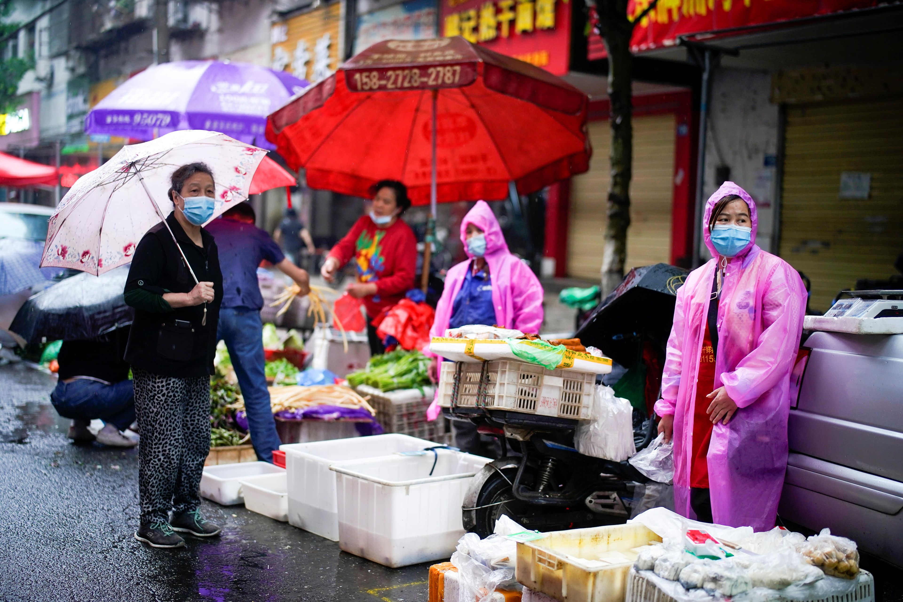 Residentes con mascarillas en un mercado callejero en Wuhan, China.
