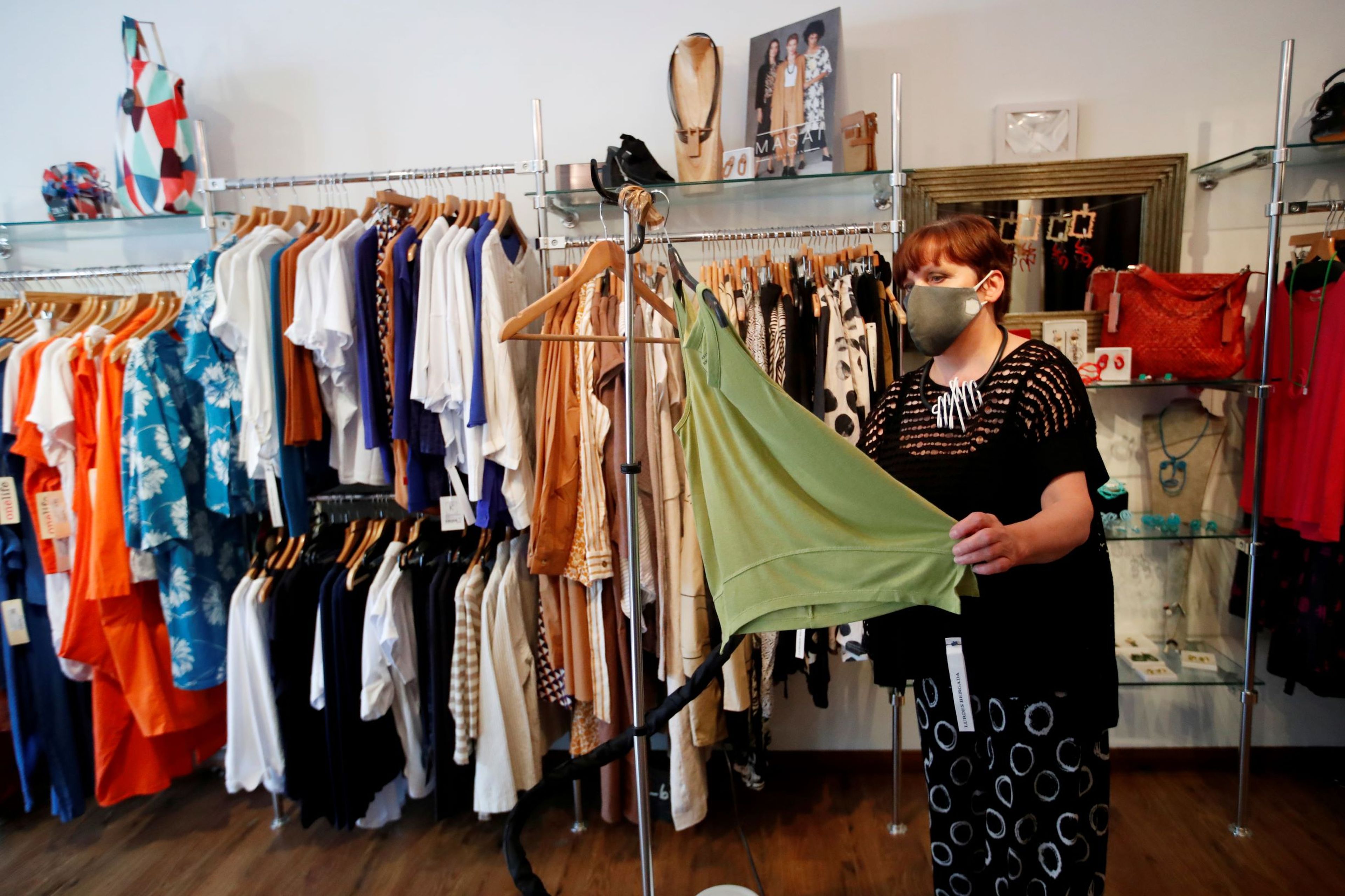 Una mujer limpia la ropa de su tienda con vapor durante el coronavirus.