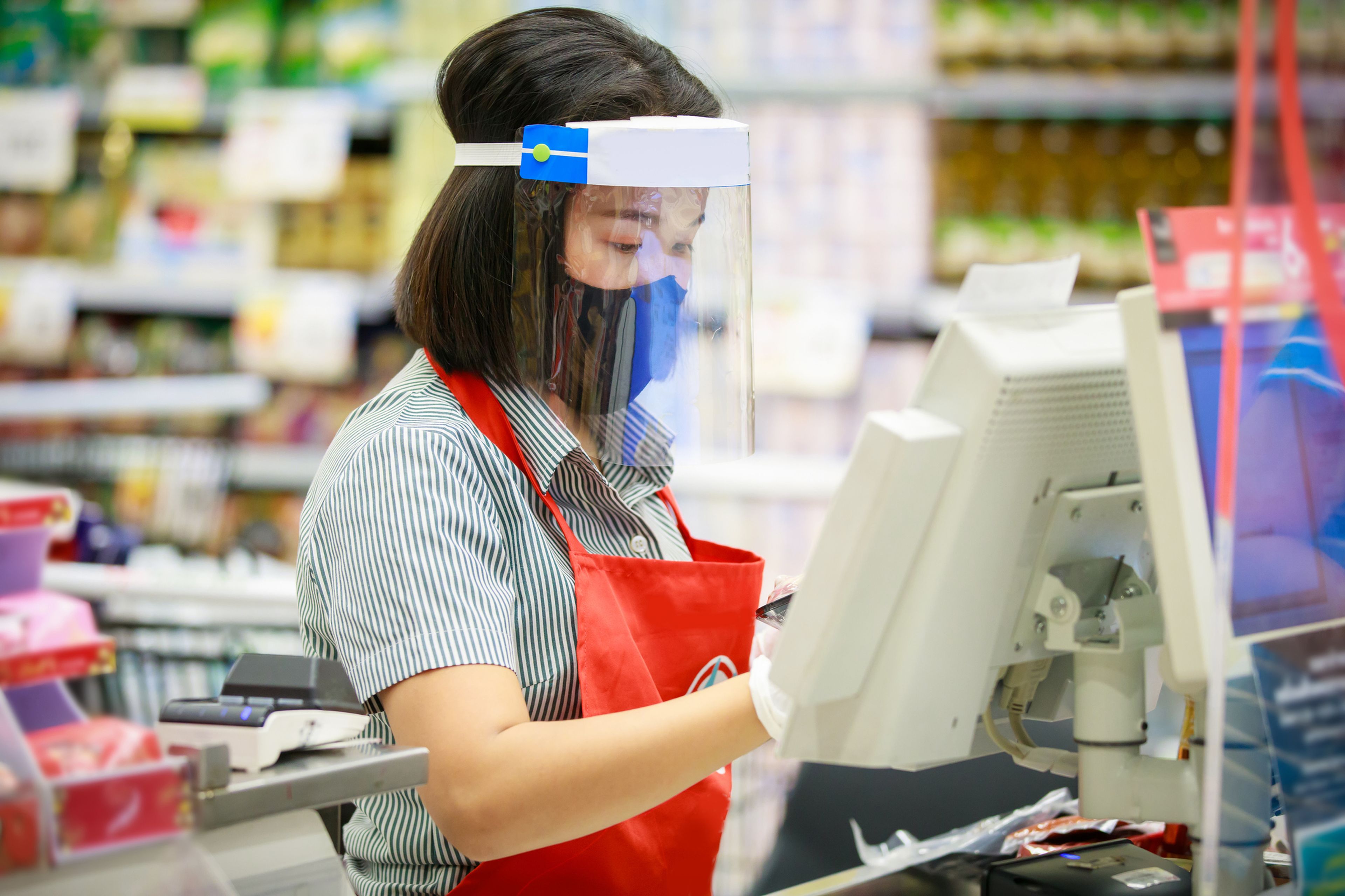 Mujer con pantalla de protección facial en un supermercado