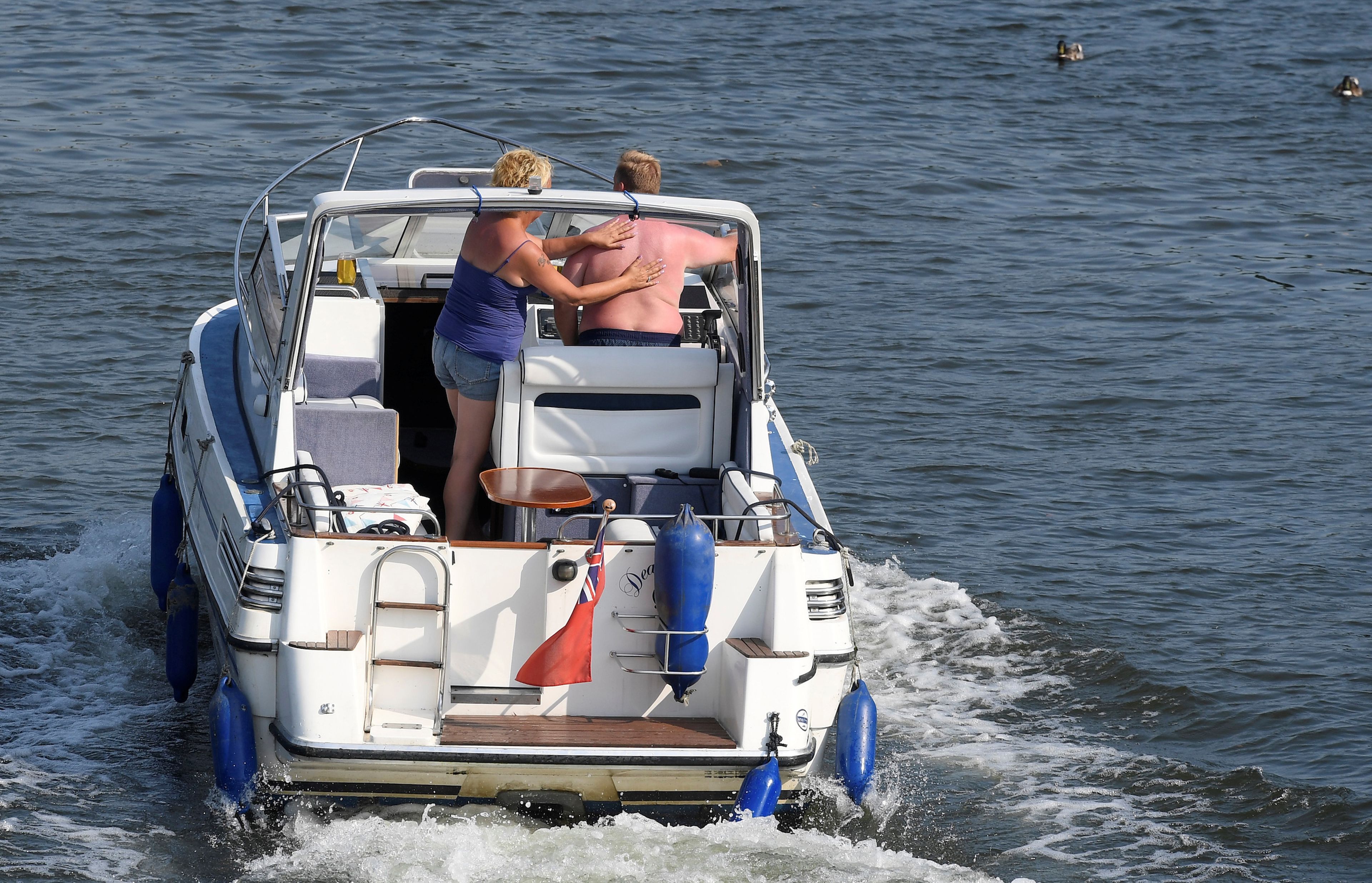 Una pareja conduce su crucero a motor a lo largo del río Támesis en el oeste de Londres, Gran Bretaña.