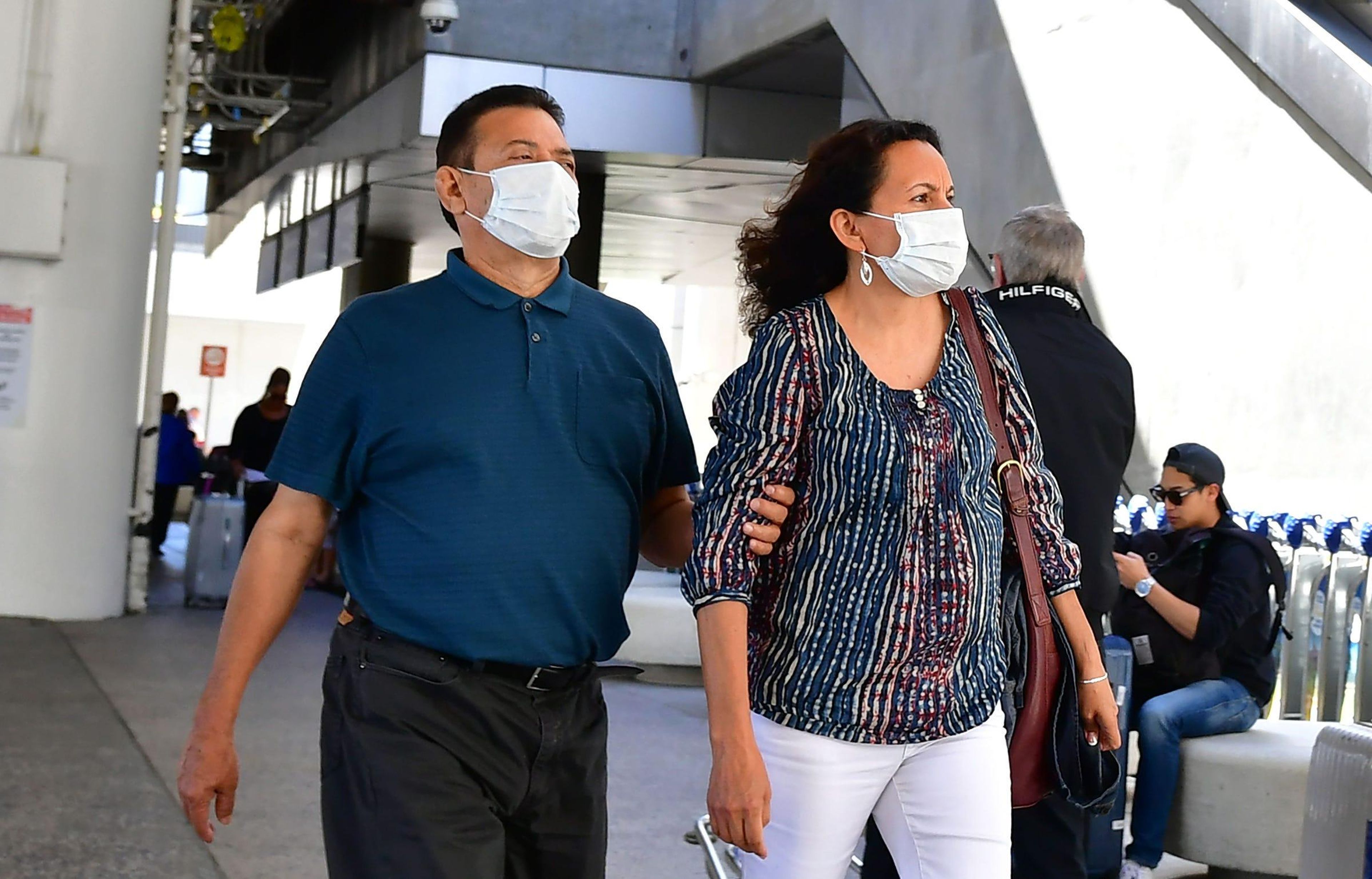 People wear face masks at Los Angeles International Airport (LAX) in Los Angeles, California on March 2, 2020.