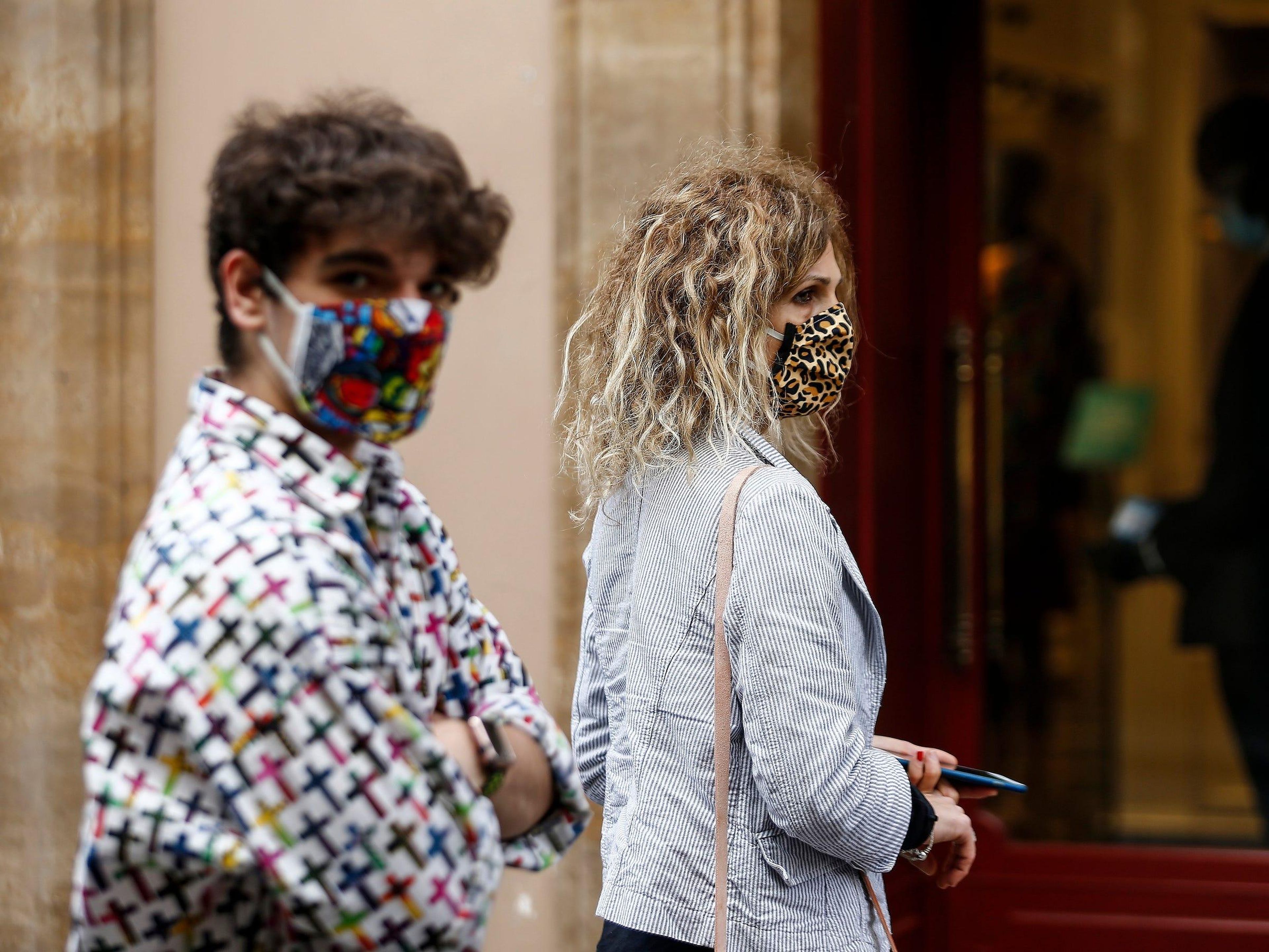 People wearing sanitary masks walk in Via Condotti shopping street, in Rome, Italy, Monday, May 18, 2020. Italy is slowly lifting sanitary restrictions after a two-month coronavirus lockdown. (Cecilia Fabiano/LaPresse via AP)