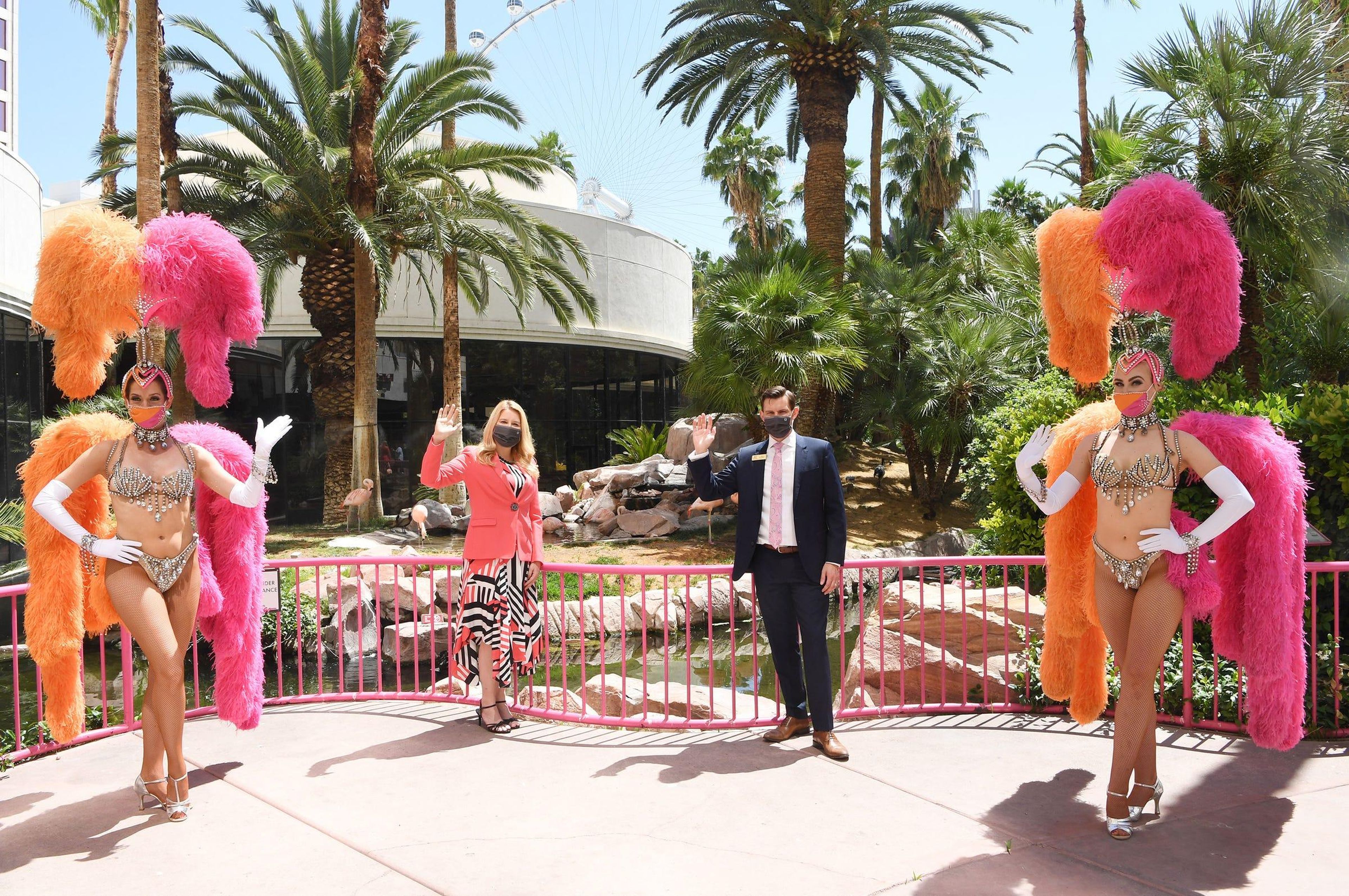La presidenta regional de Caesars Entertainment, Eileen Moore, y el director general de Flamingo Las Vegas, Ken Janssen, posan con las bailarinas en la reapertura del Flamingo Las Vegas el 4 de junio de 2020.