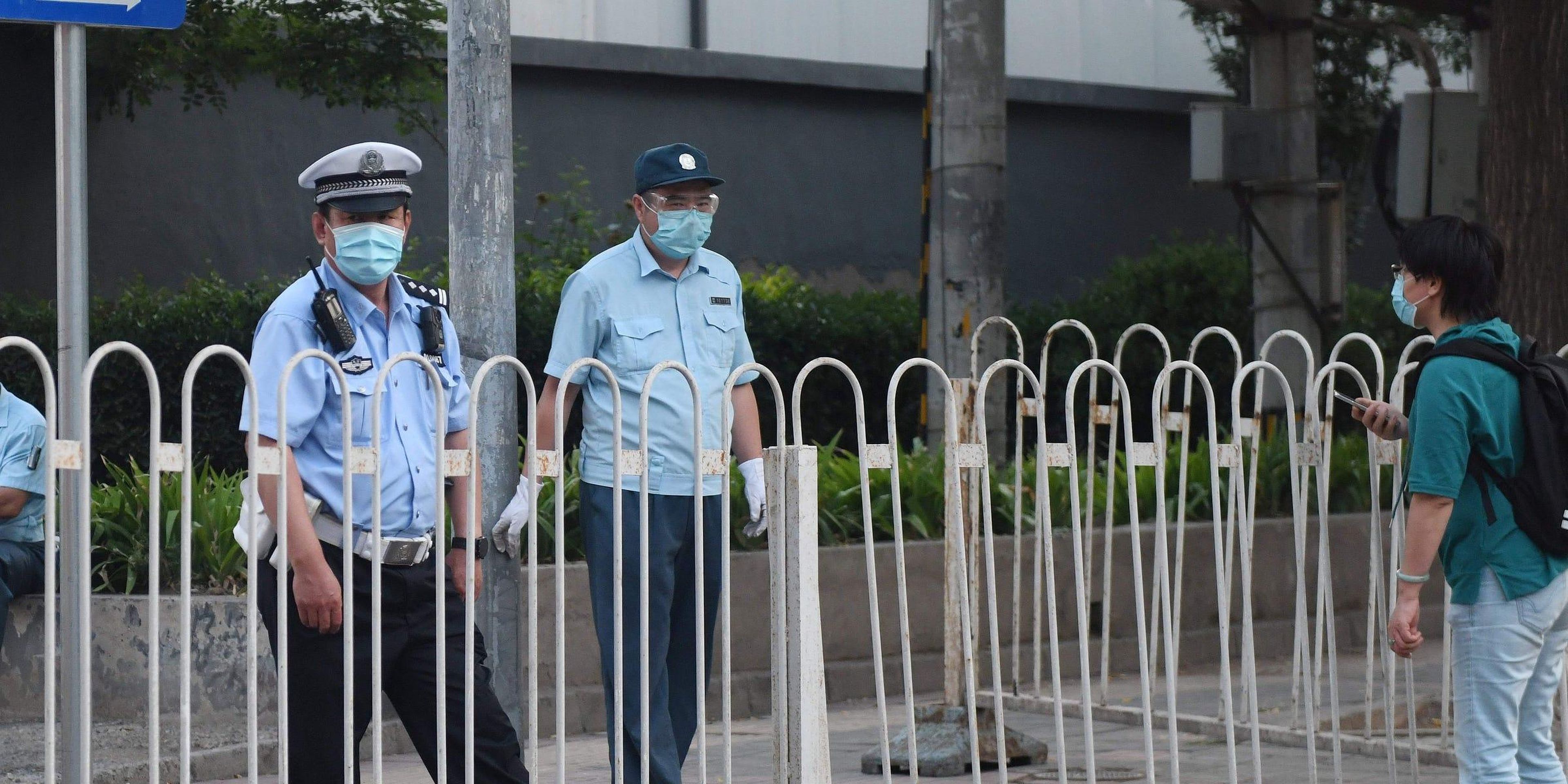 Un oficial de policía bloqueando la entrada a un complejo residencial aislado cerca del clausurado mercado Xinfadi en Pekín el 13 de junio de 2020.