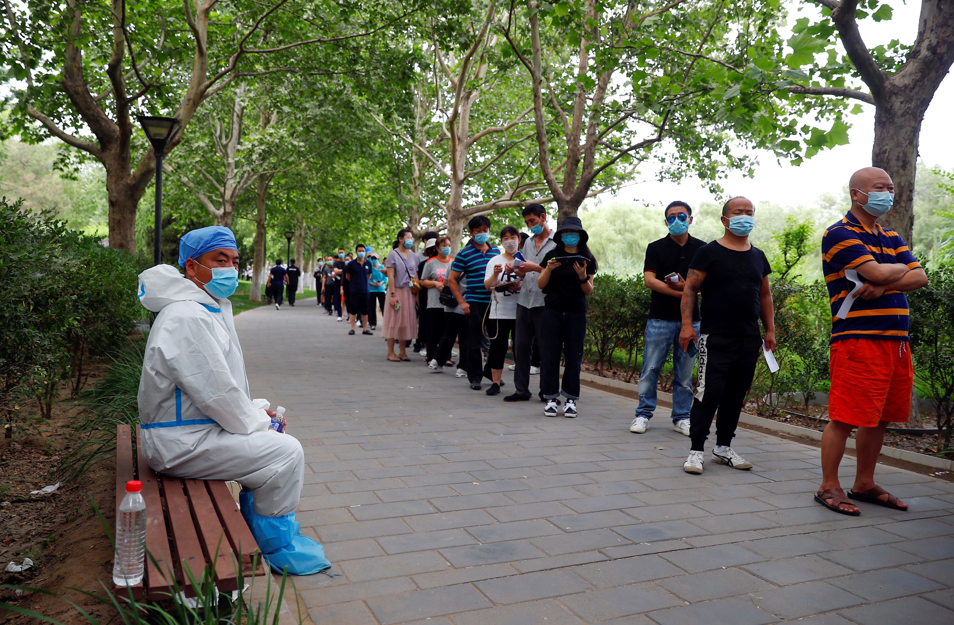 Residentes de Pekín hacen fila para hacerse una prueba de ácido nucleico en un parque en el distrito de Fengtai.