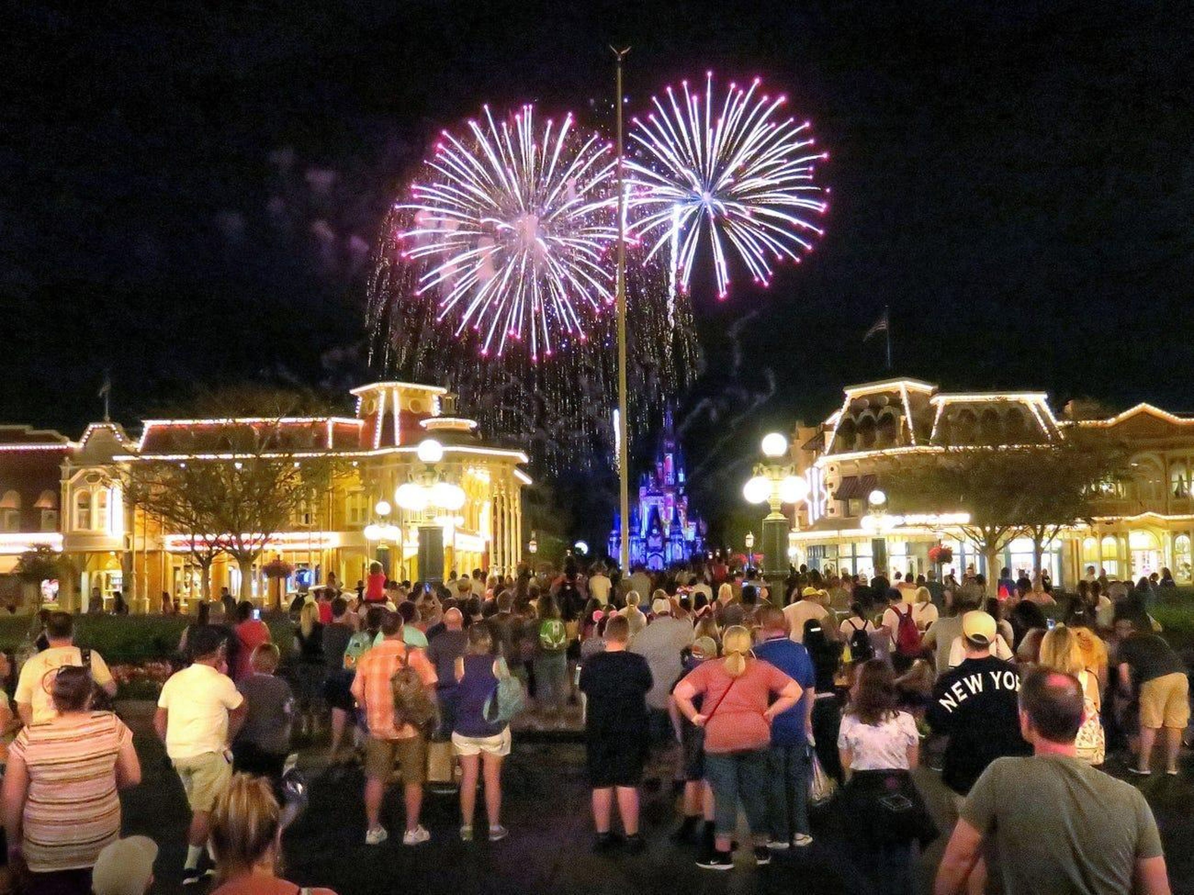 Gente viendo fuegos artificiales en Walt Disney World Orlando antes de que el parque cerrara el 15 de marzo.