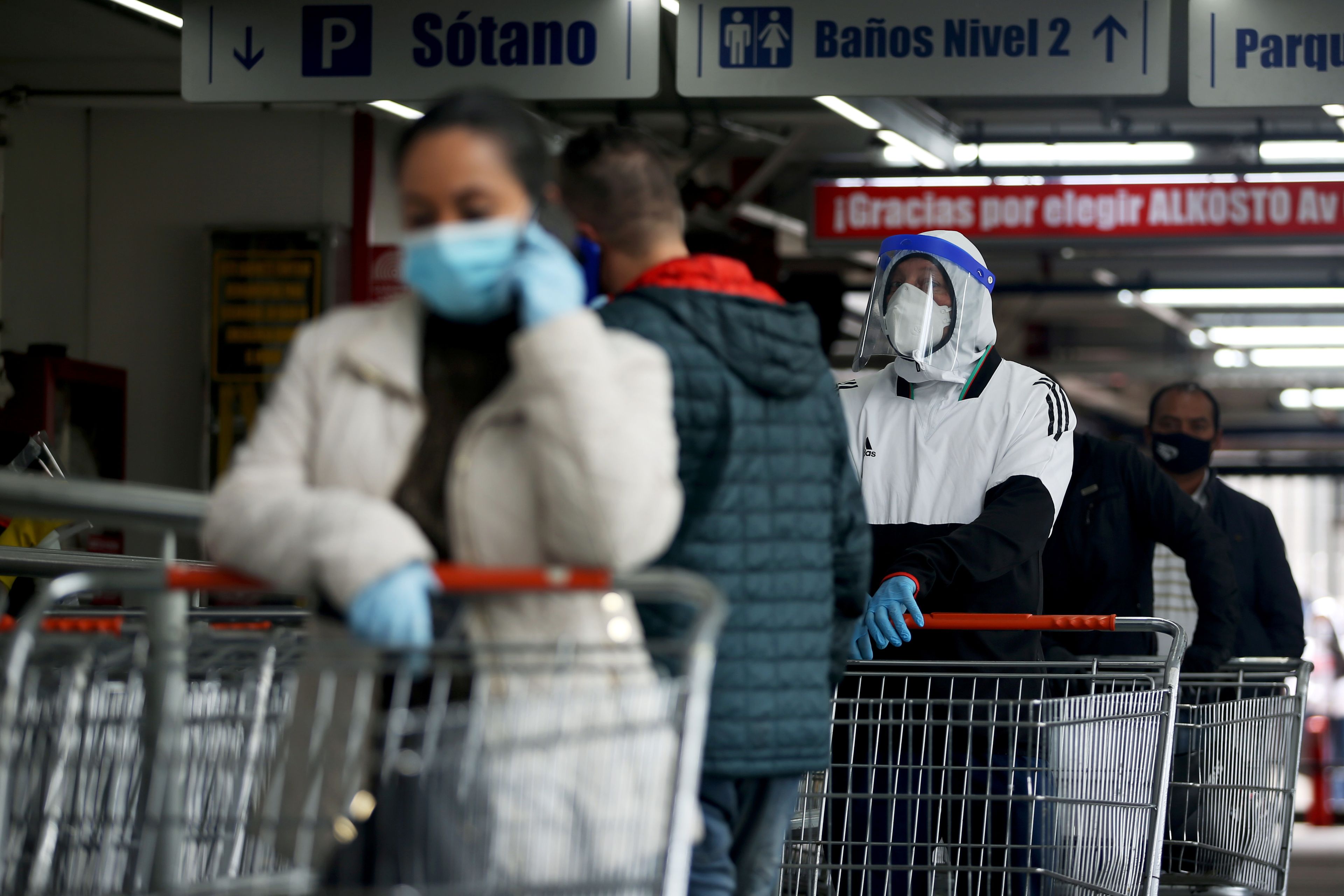 Varias personas haciendo la compra con mascarillas durante el coronavirus en Colombia.