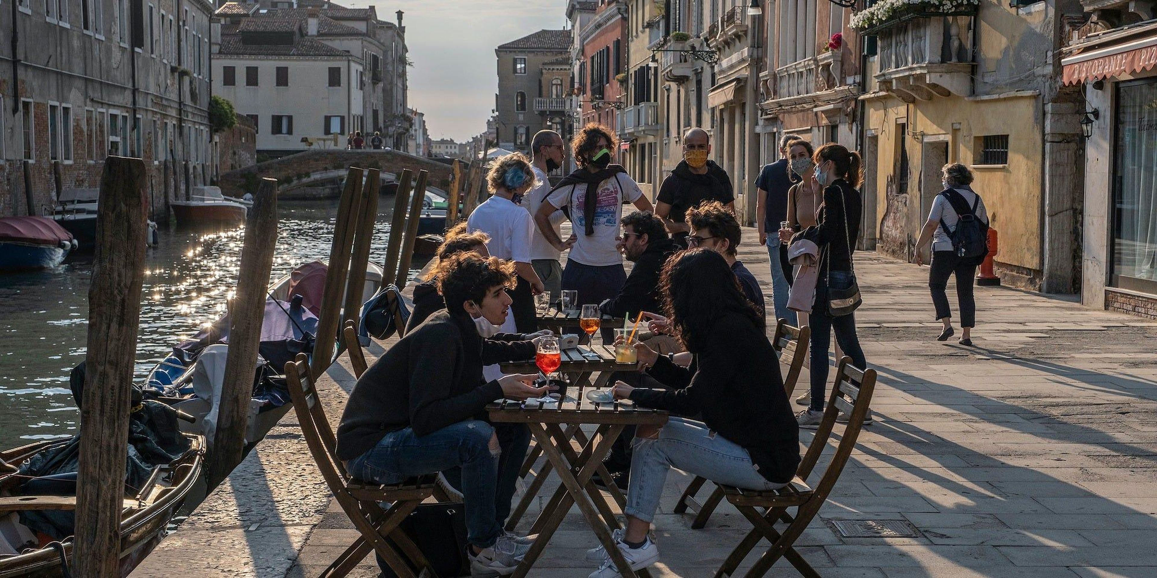 Los venecianos toman el aperitivo en un bar el 20 de mayo de 2020. Restaurantes, bares, cafés, peluquerías y otras tiendas han reabierto, sujetos a medidas de distanciamiento social, después de más de dos meses.