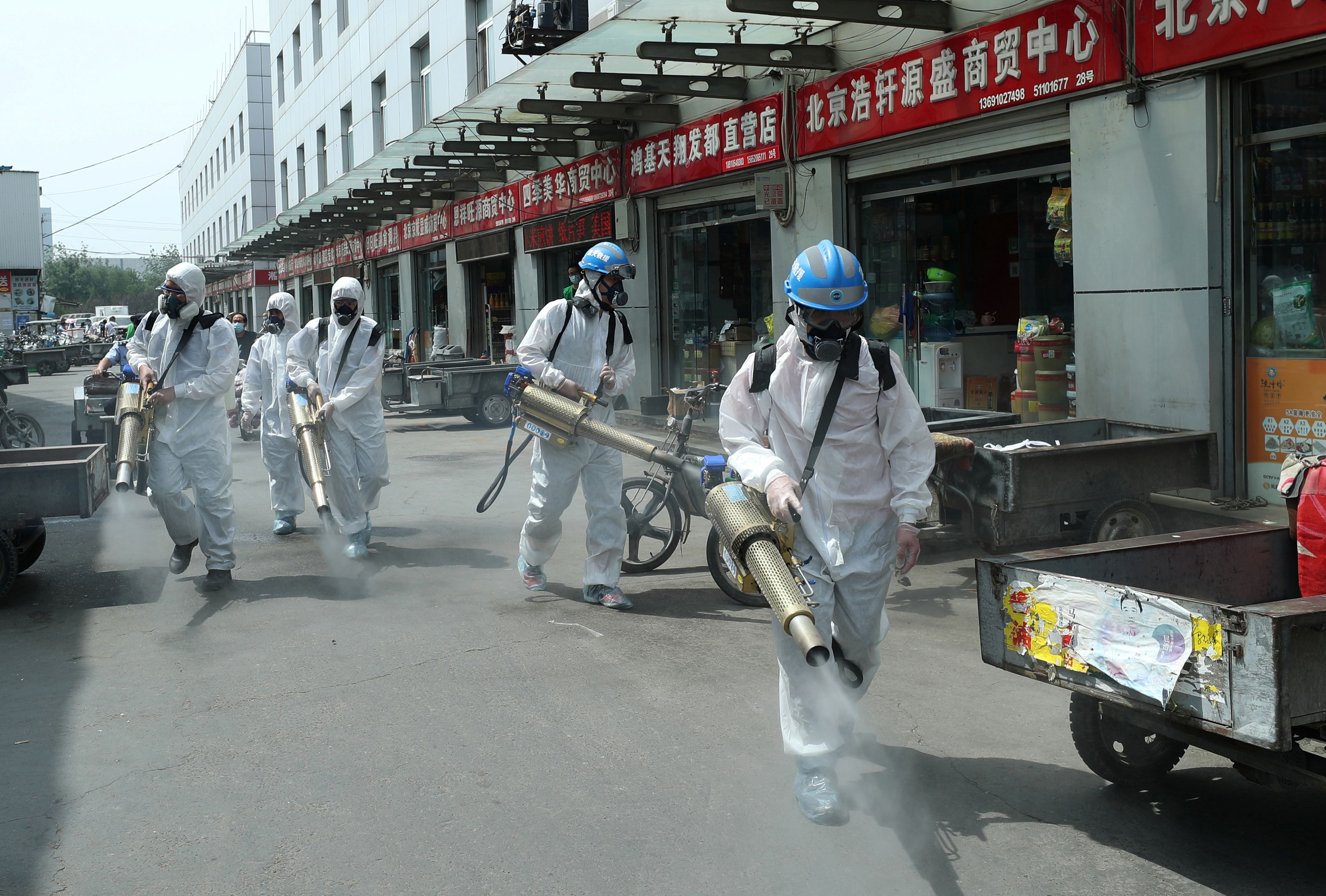 Voluntarios del equipo de rescate de Blue Sky desinfectan el mercado mayorista de Yuegezhuang en Beijing en medio del rebrote de coronavirus.