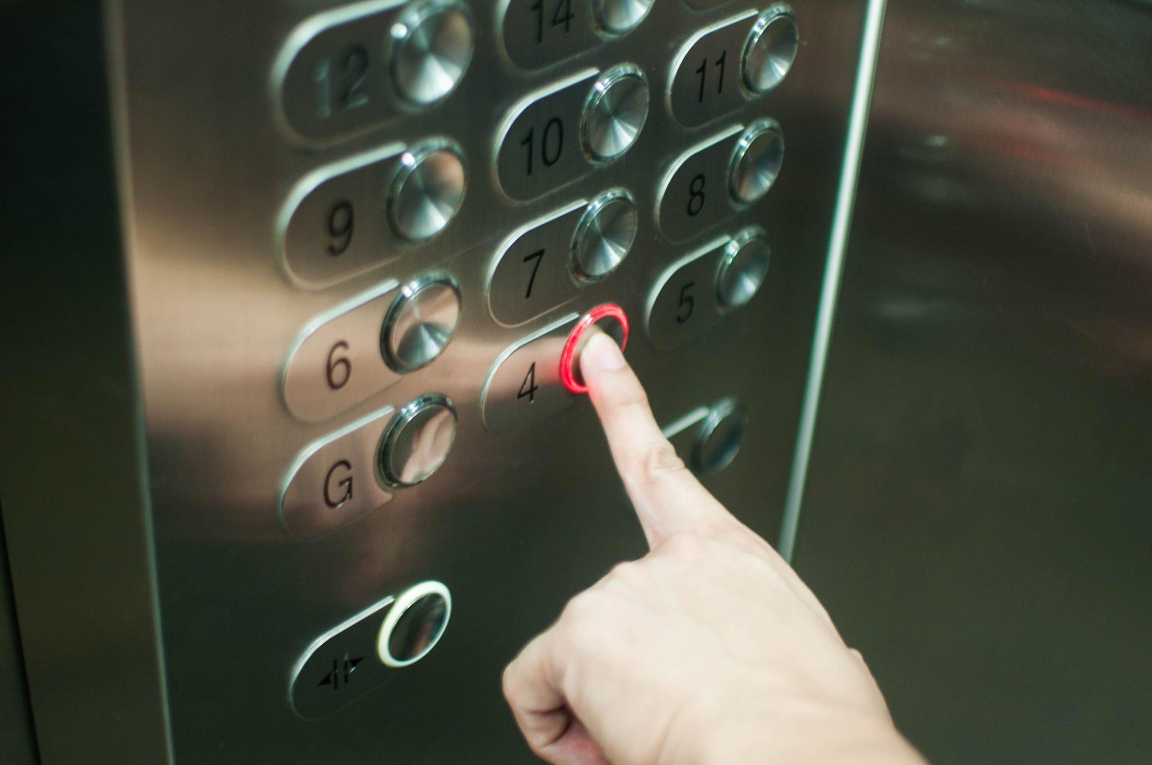Una mujer presiona el botón de un ascensor.