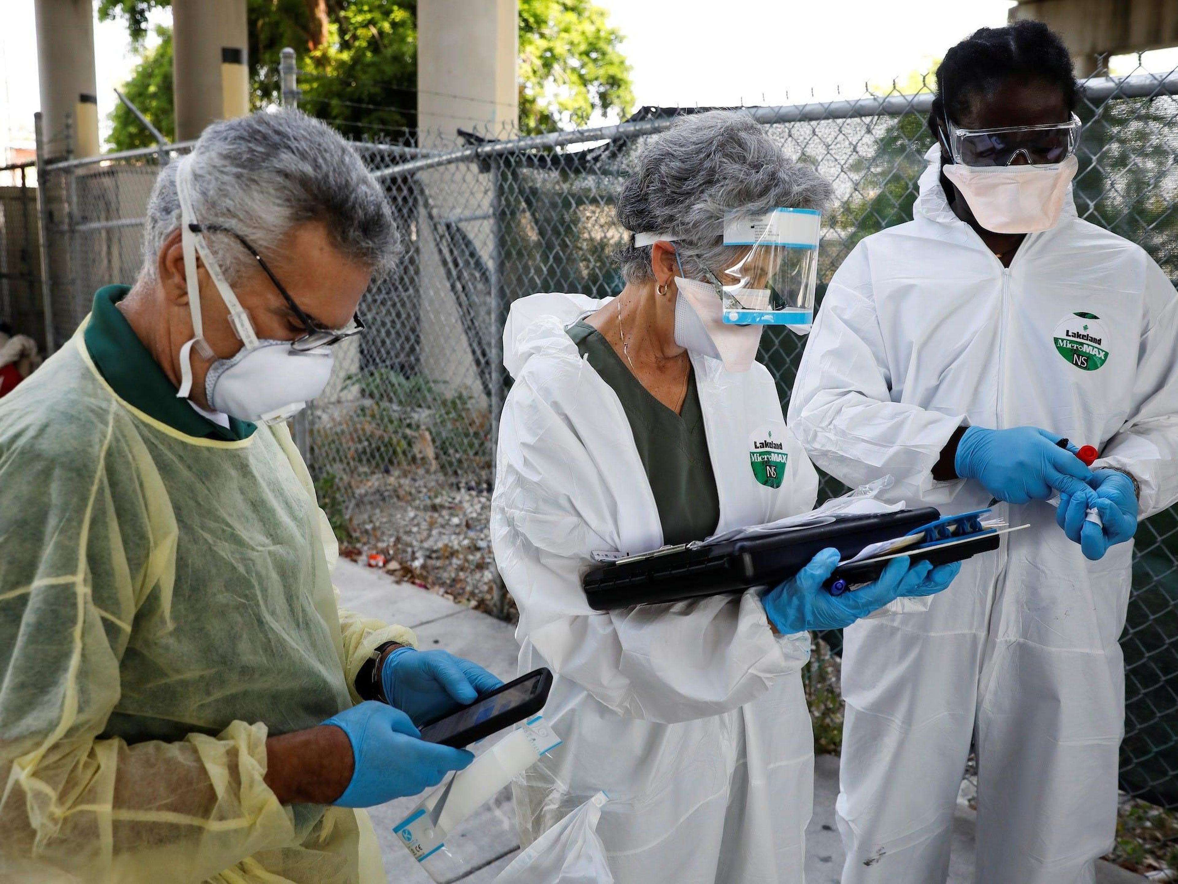 Trabajadores recogen muestras de personas sin hogar durante una acción de pruebas de coronavirus en el condado de Miami-Dade, en Florida, el 16 de abril de 2020.