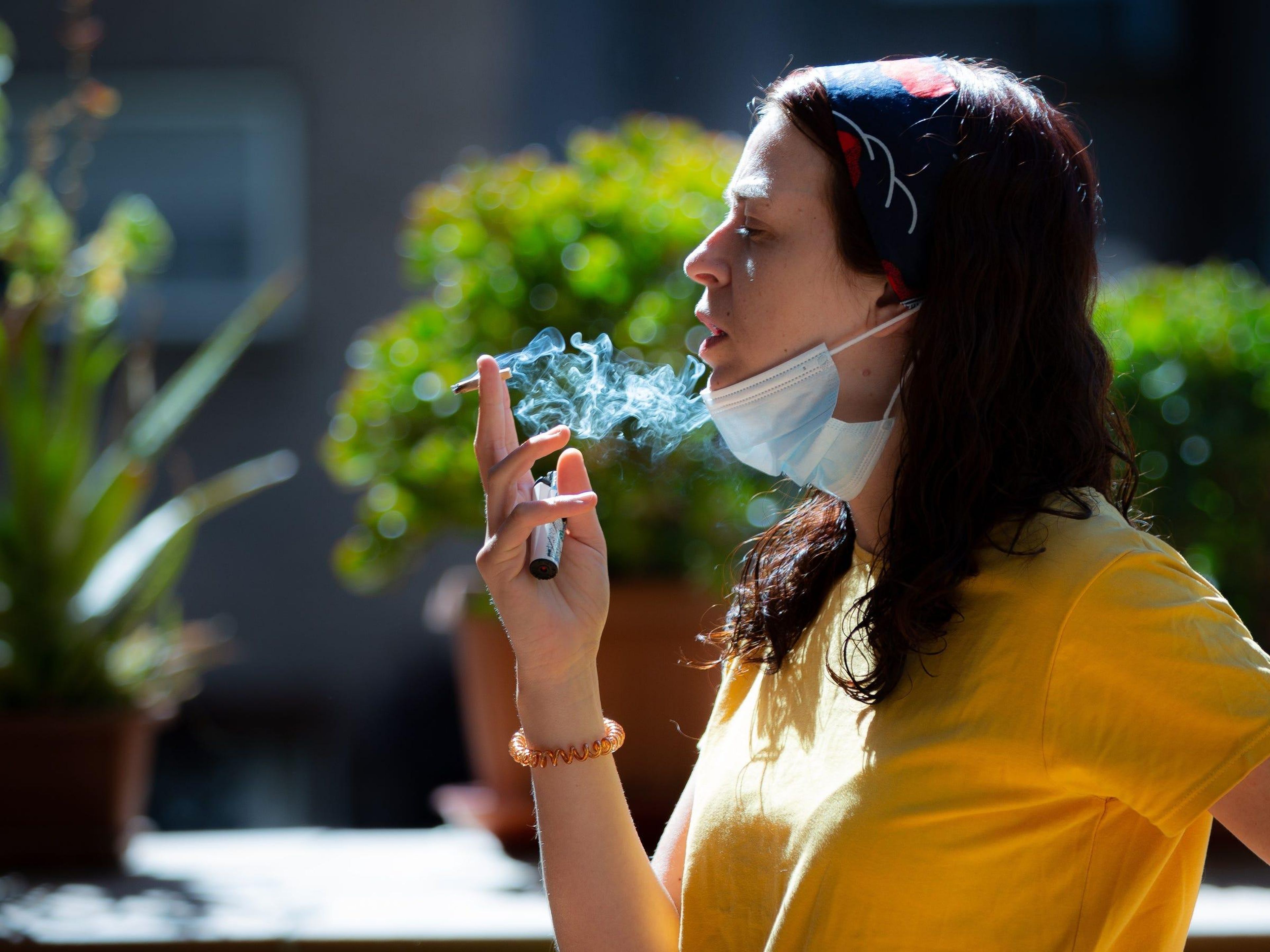 Una mujer con mascarilla, fumando, 6 de junio de 2020 en Madrid, España. .