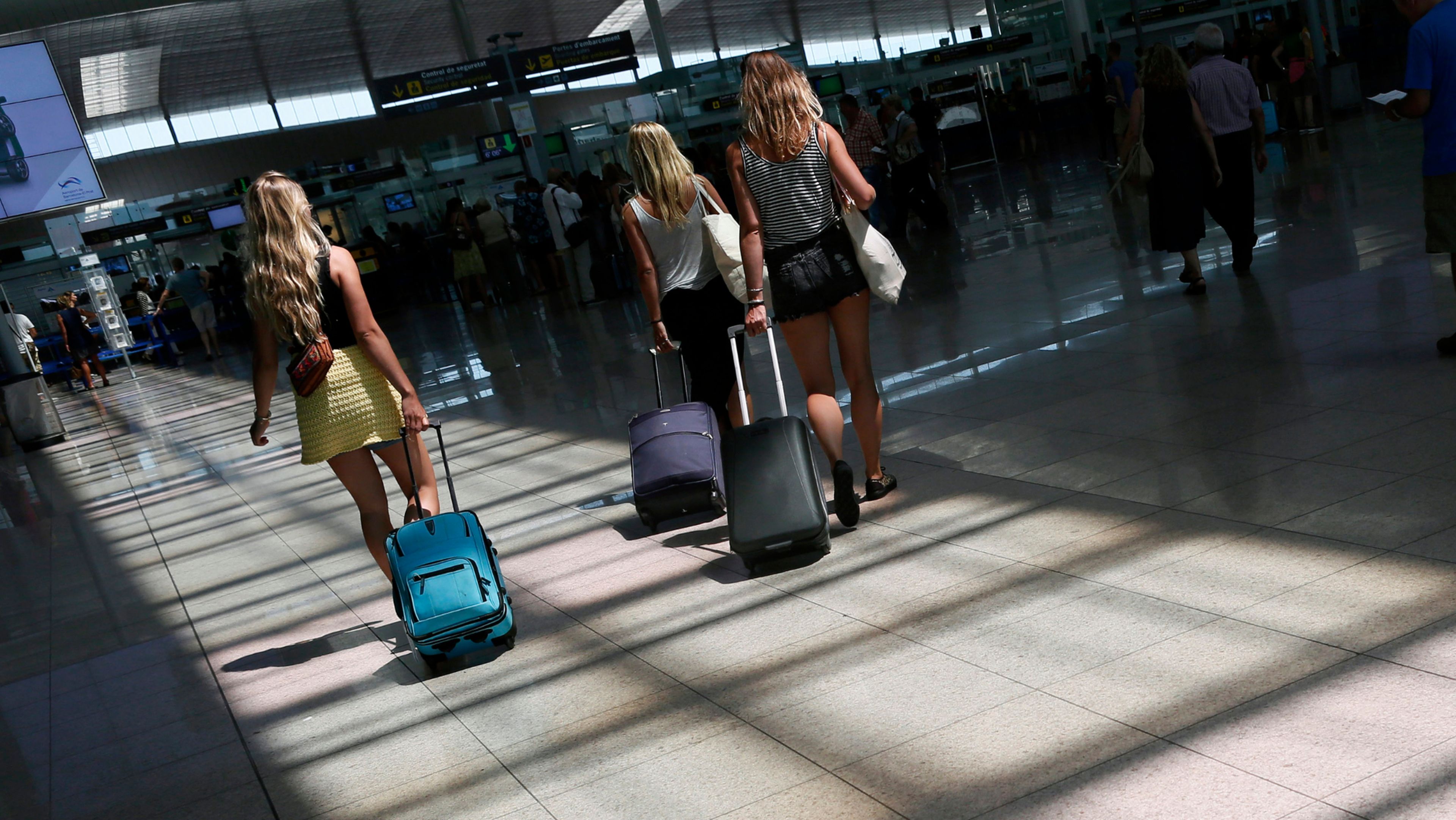 3 jóvenes se dirigen a su puerta de embarque en el aeropuerto de Barcelona-El Prat