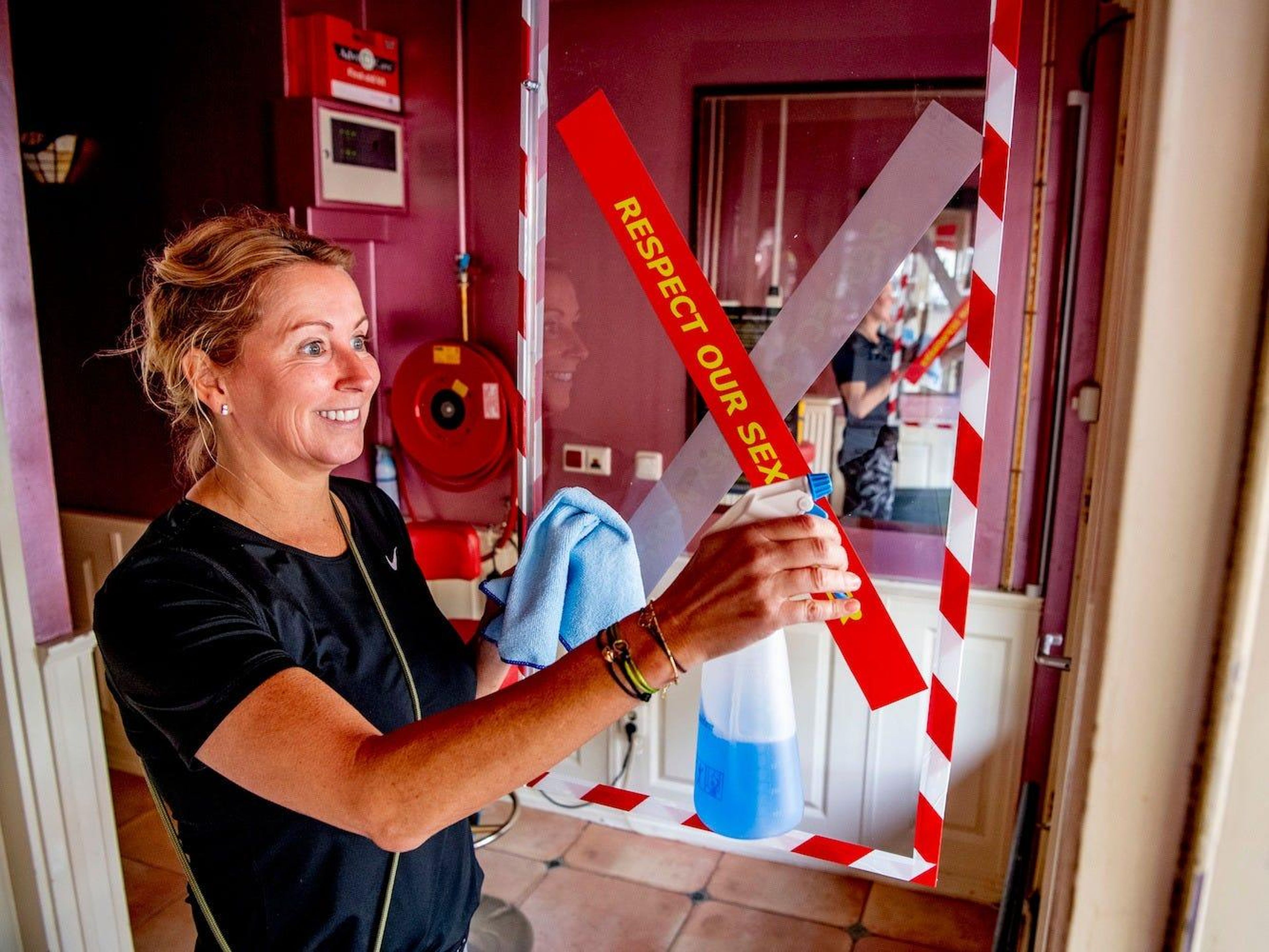 Una limpiadora desinfectando un edificio del barrio rojo el 30 de junio de 2020 en Amsterdam, Países Bajos.