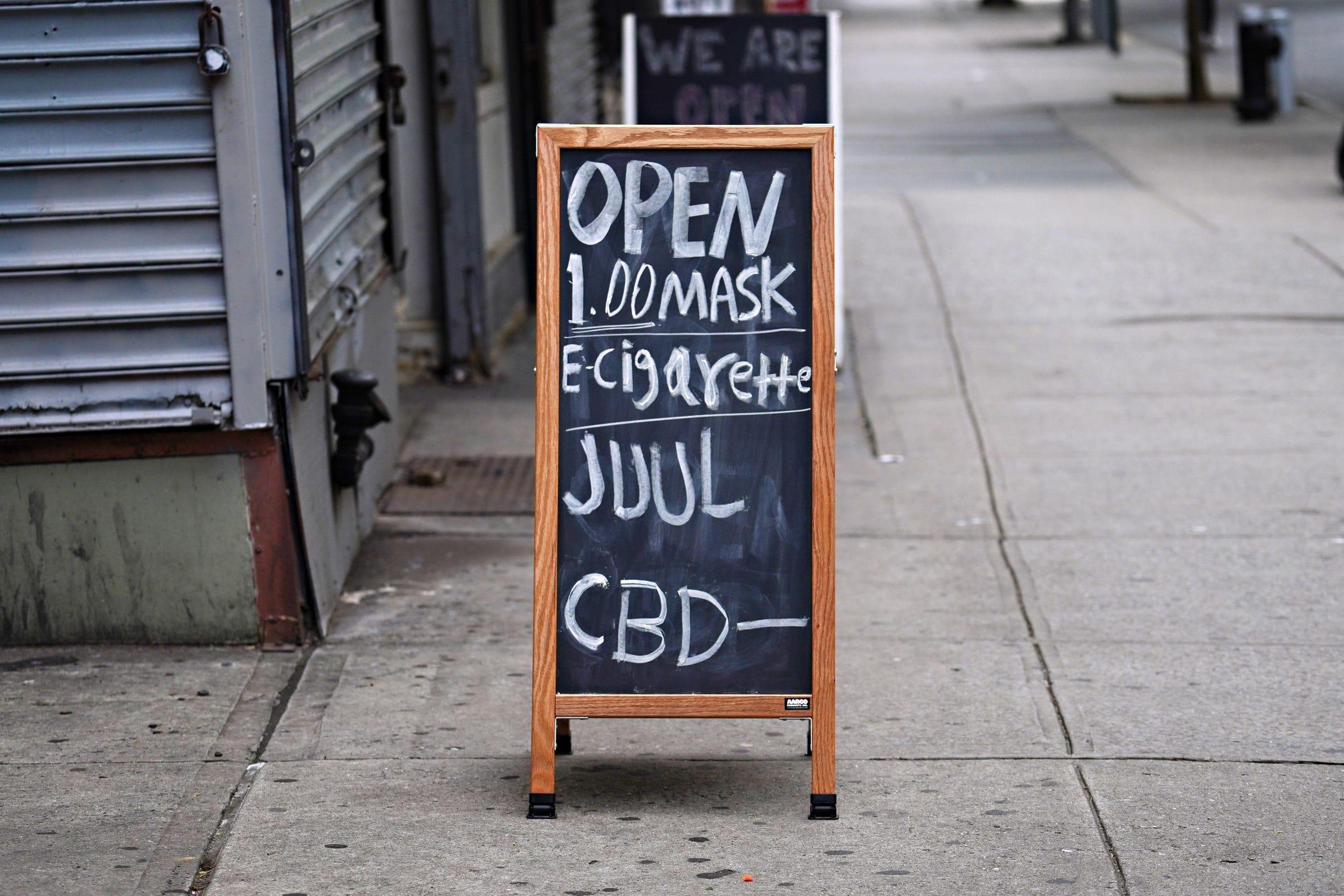 Un negocio muestra un cartel de venta de mascarillas, cigarrillos electrónicos y CBD durante la pandemia de coronavirus, el 27 de mayo de 2020, en Nueva York, EEUU.