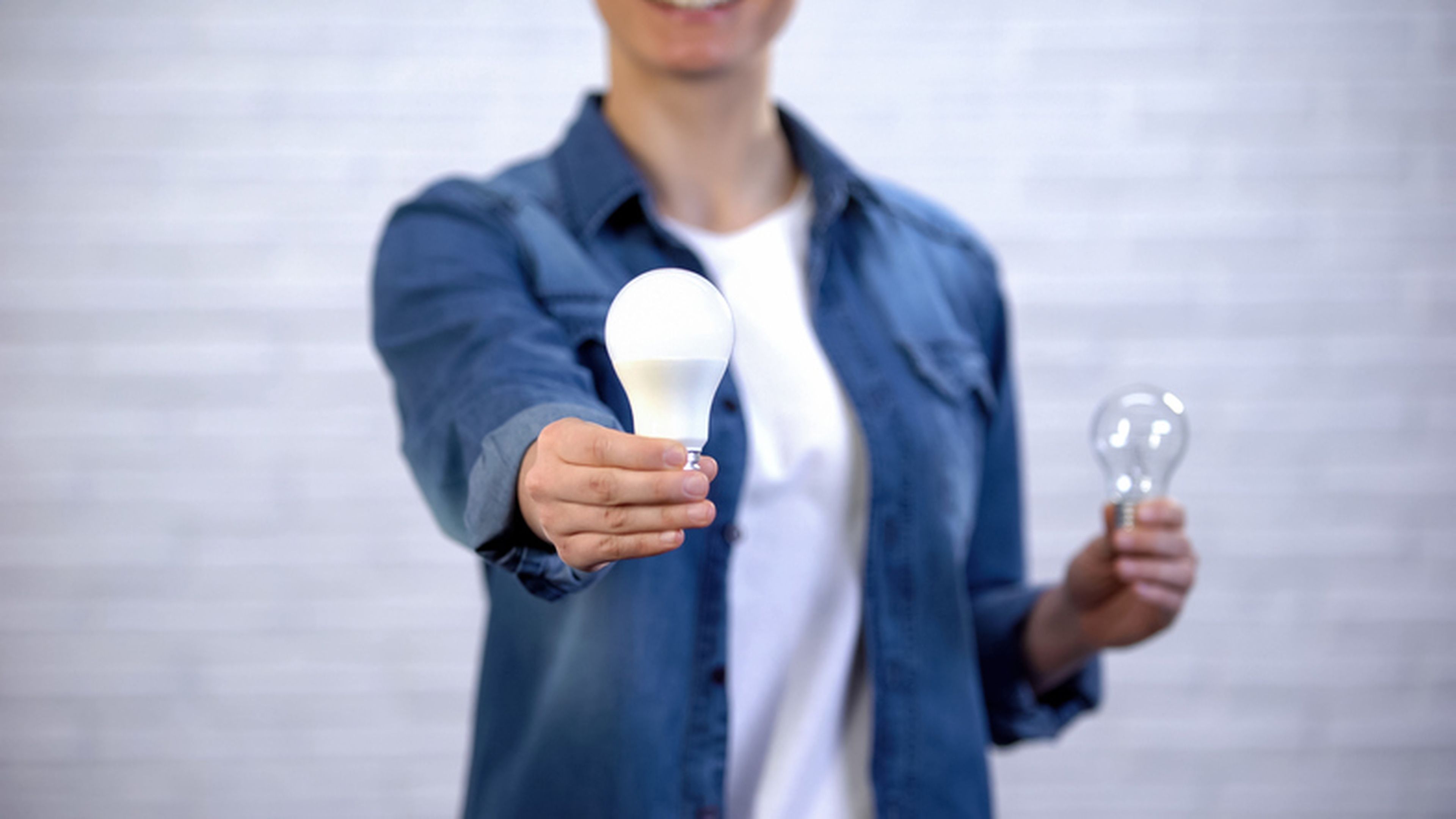 Chica elige la bombilla led de ahorro de energía en lugar de la lámpara incandescente, la eficiencia