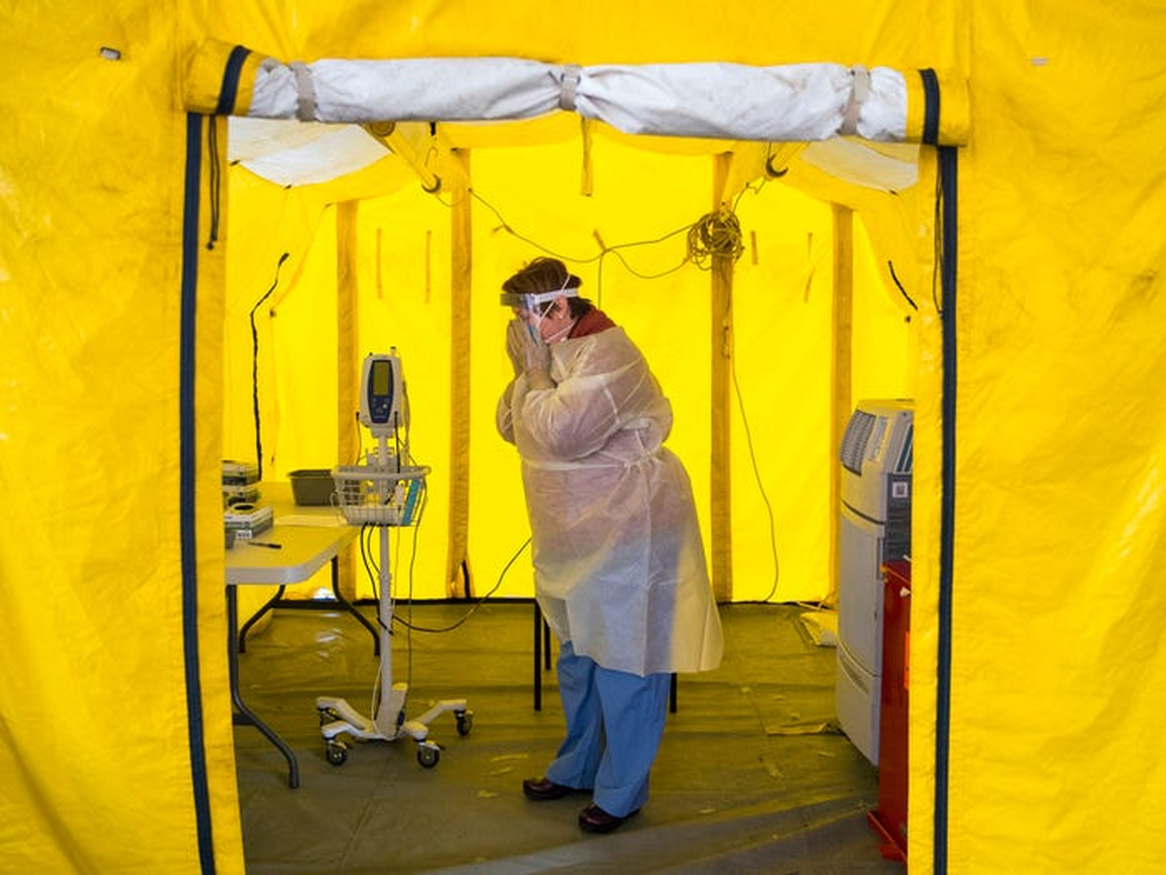 Una enfermera practicante se pone el equipo de protección en una tienda de campaña en el estacionamiento del Hospital Newton-Wellesley en Newton, Massachusetts, el 16 de marzo.