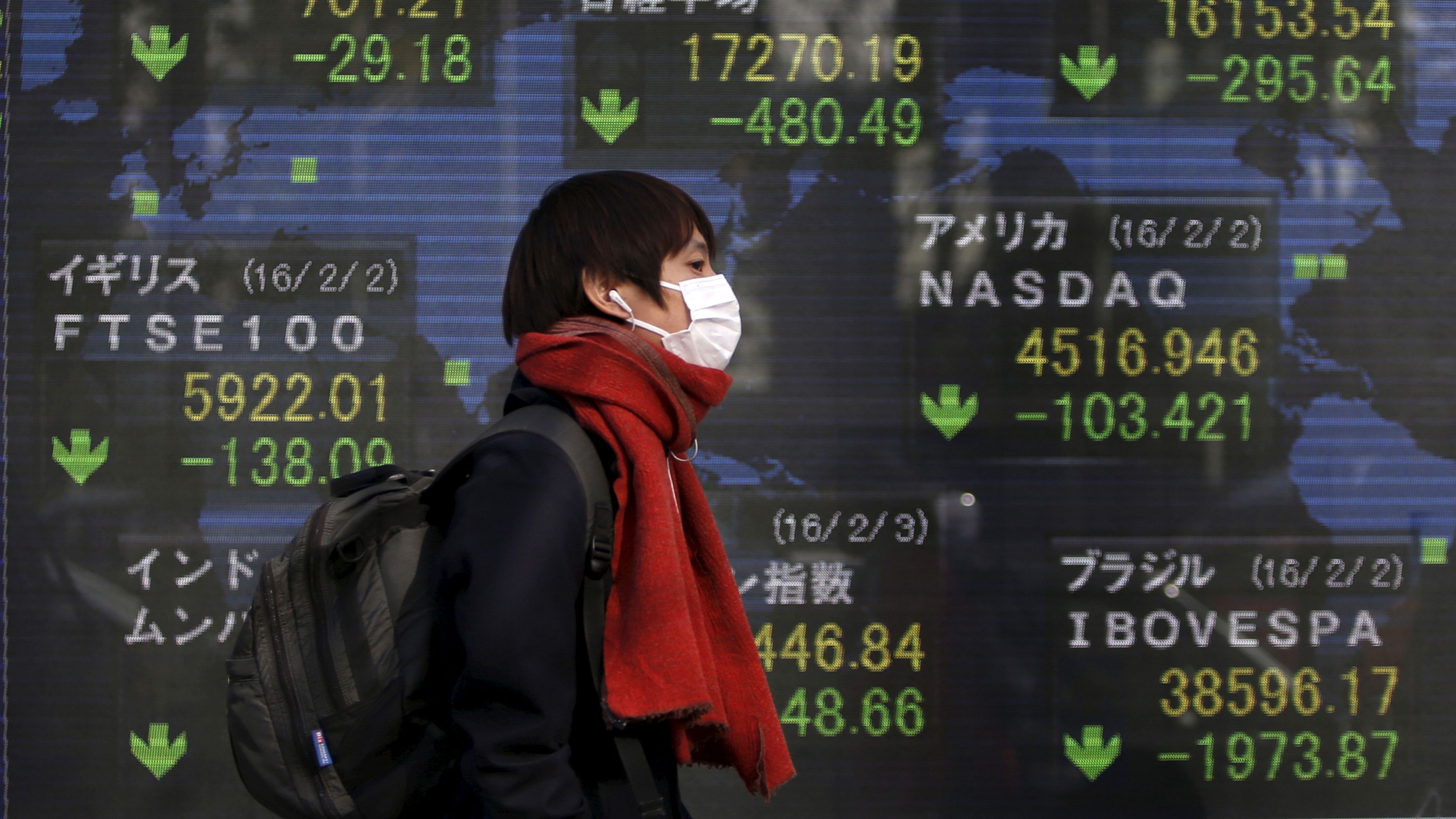Un hombre con mascarilla pasa ante las pantallas de mercados de la Bolsa de Tokio