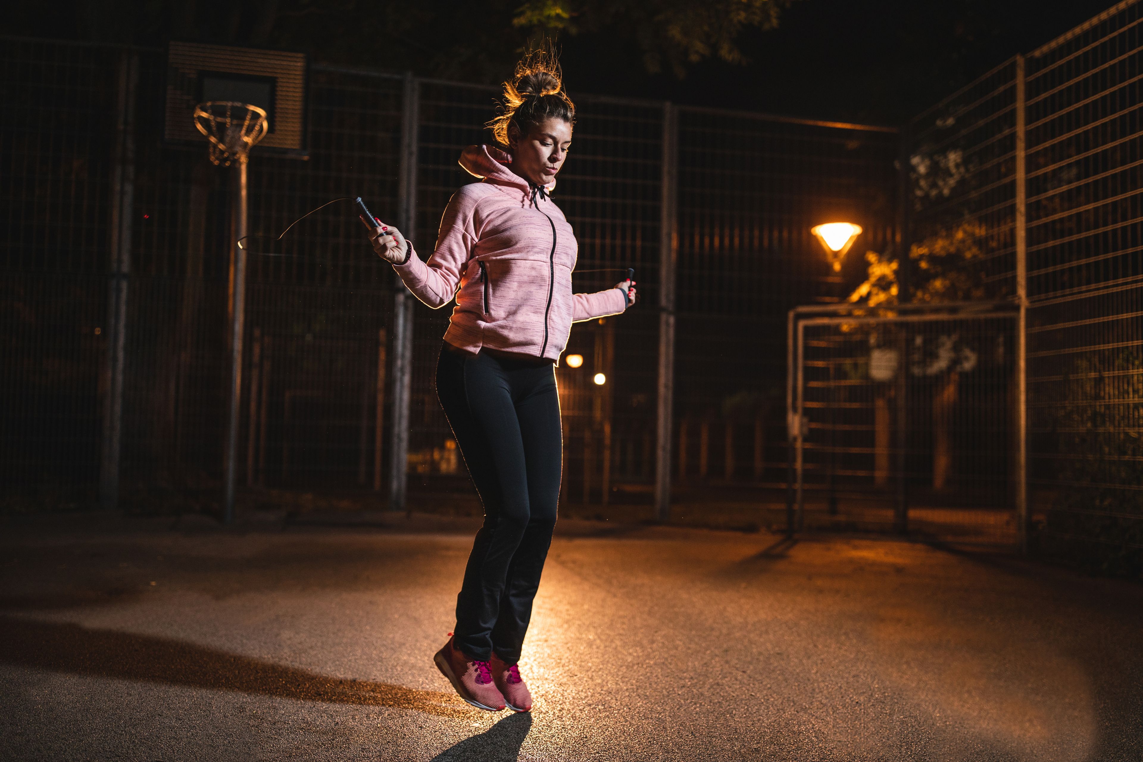 Una mujer hace ejercicio en la noche.