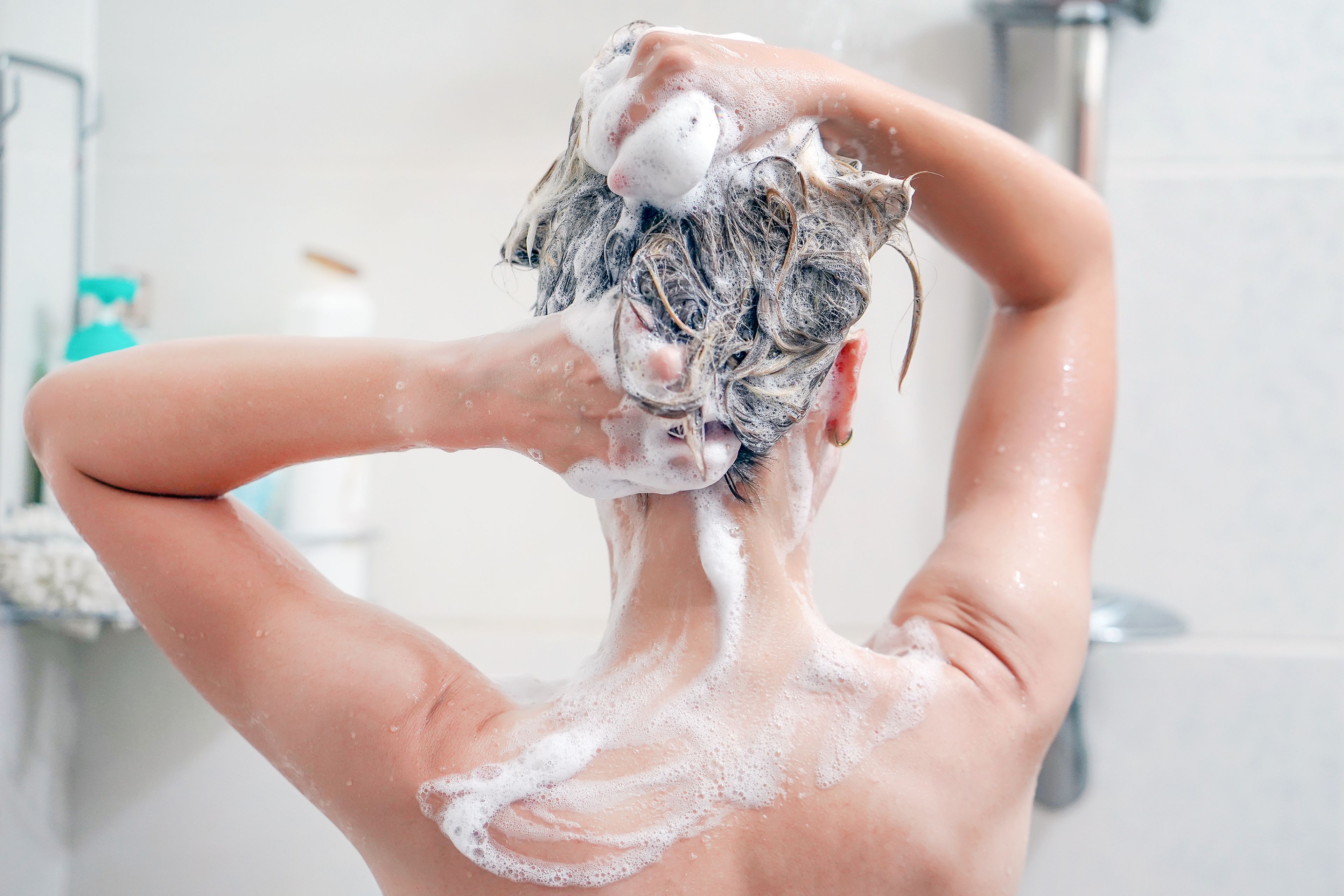Mujer lavando su pelo en la ducha