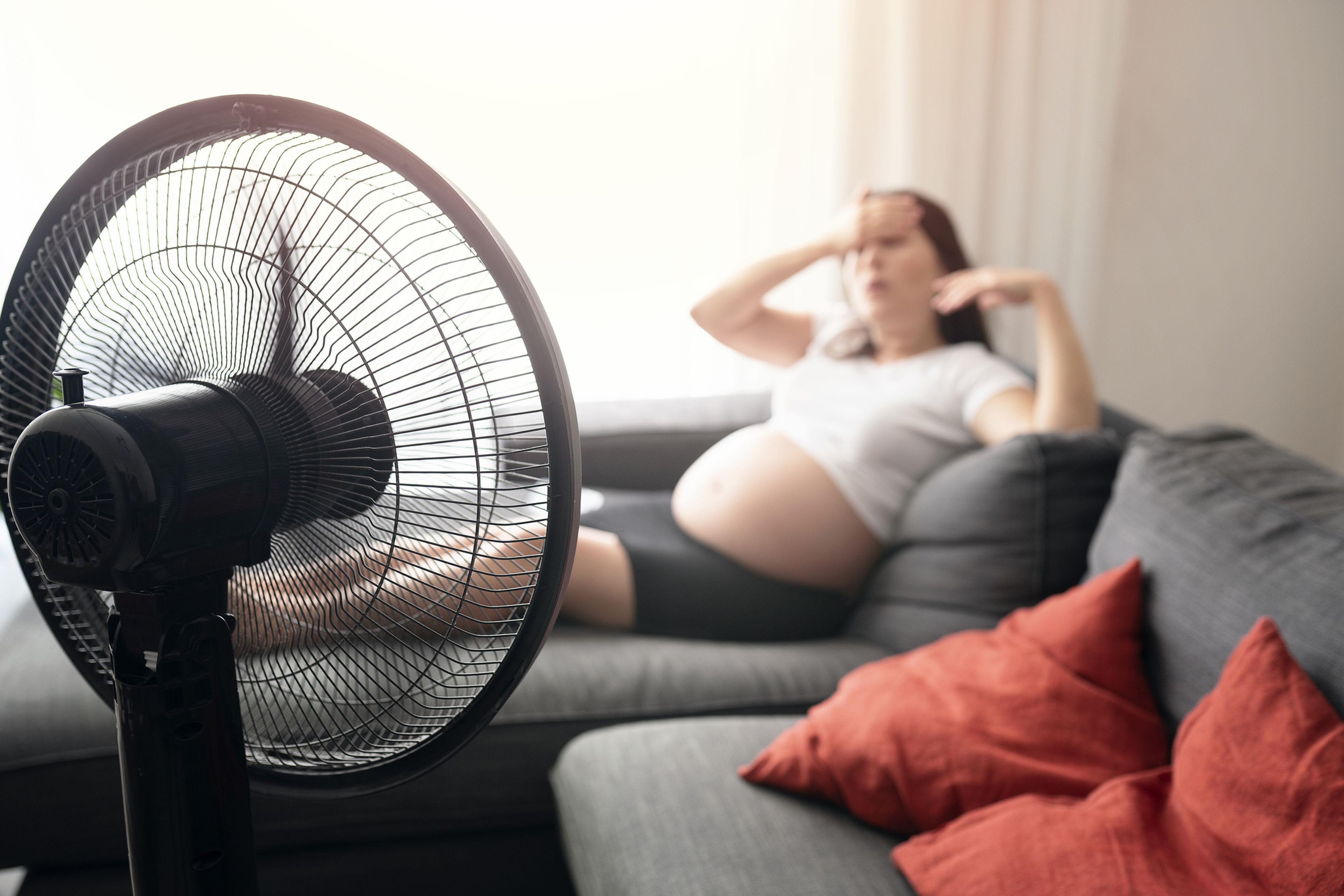 Una mujer usa un ventilador.