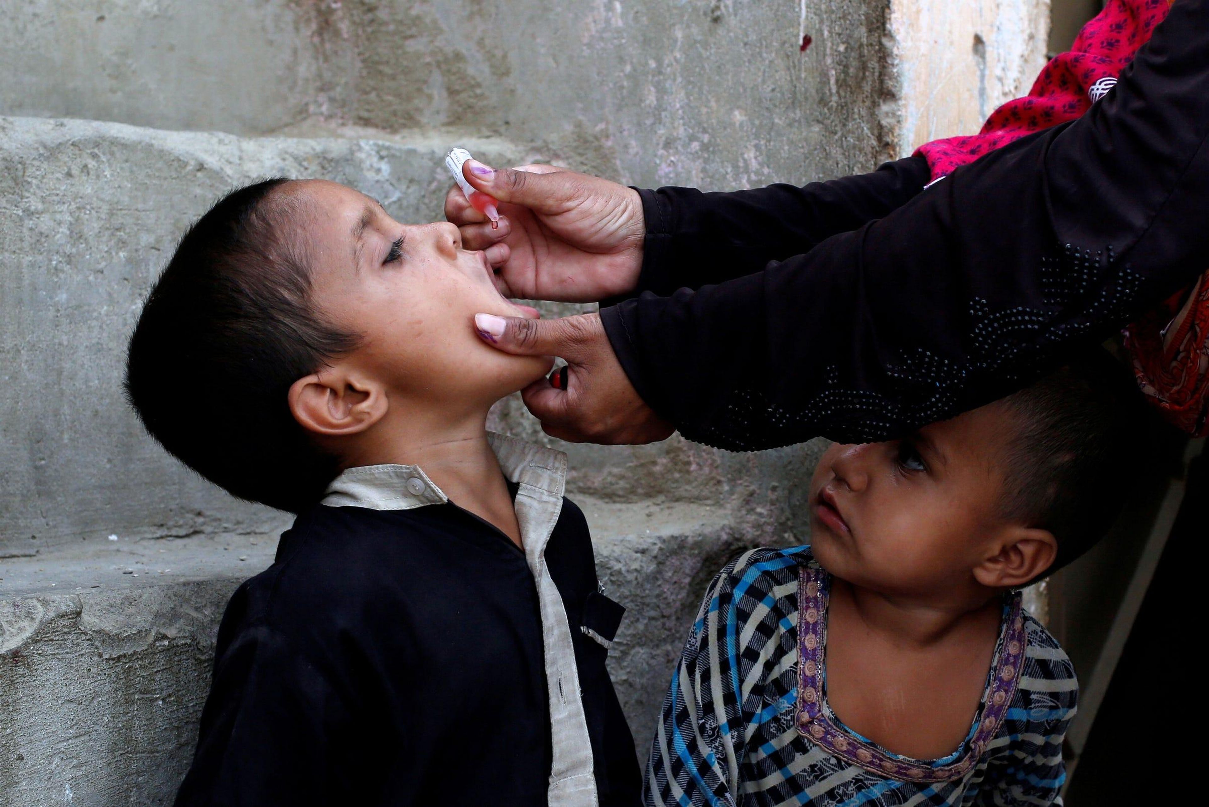 Vacunan a un niño contra la poliomielitis, durante una campaña contra la enfermedad, en un barrio pobre en Karachi, Pakistán, el 9 de abril de 2018.