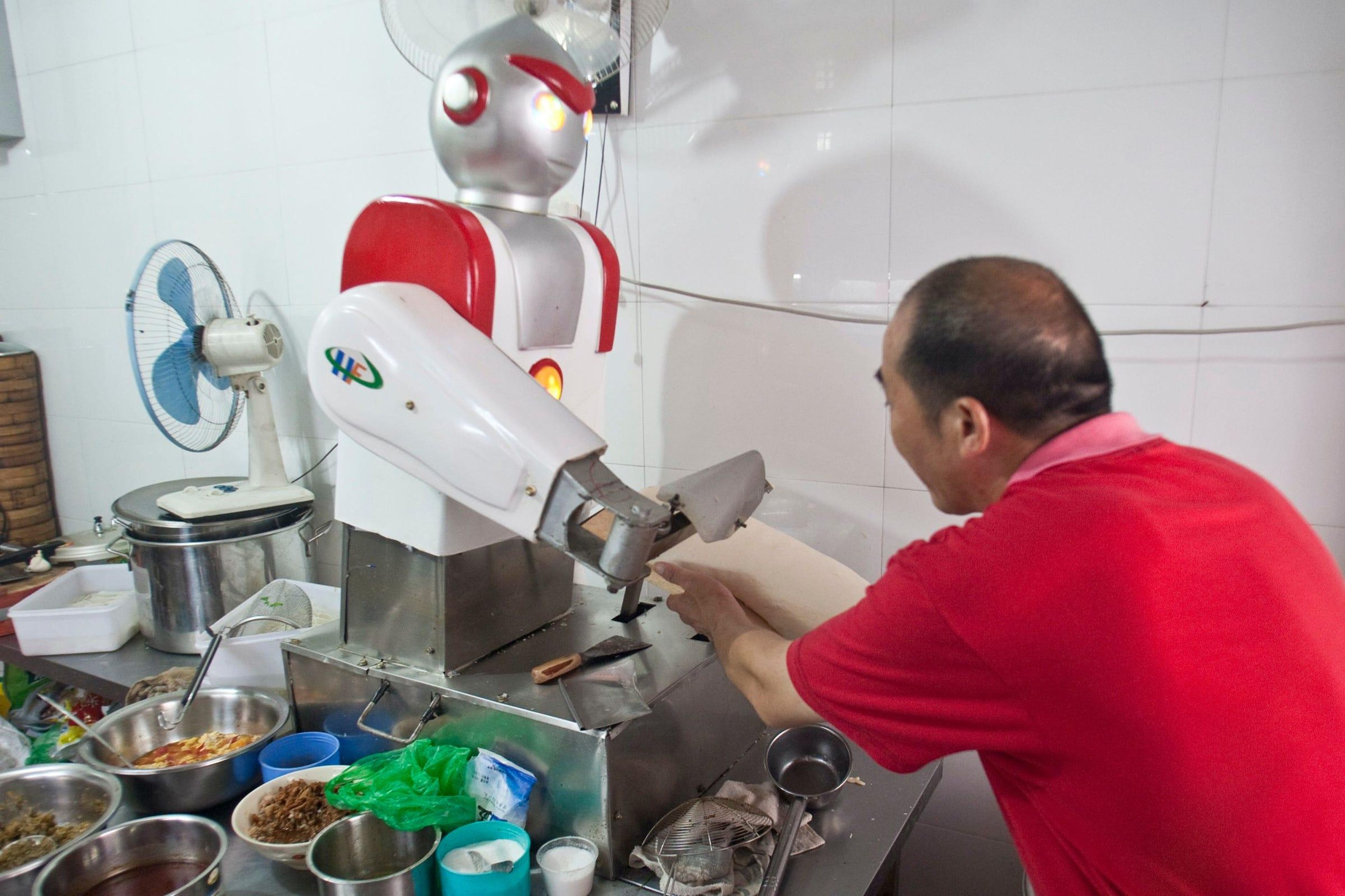 Un restaurante en Hangzhou, China, tiene un chef robot que se parece a Ultraman, un personaje de anime japonés. Este chef robot corta fideos en la cocina.