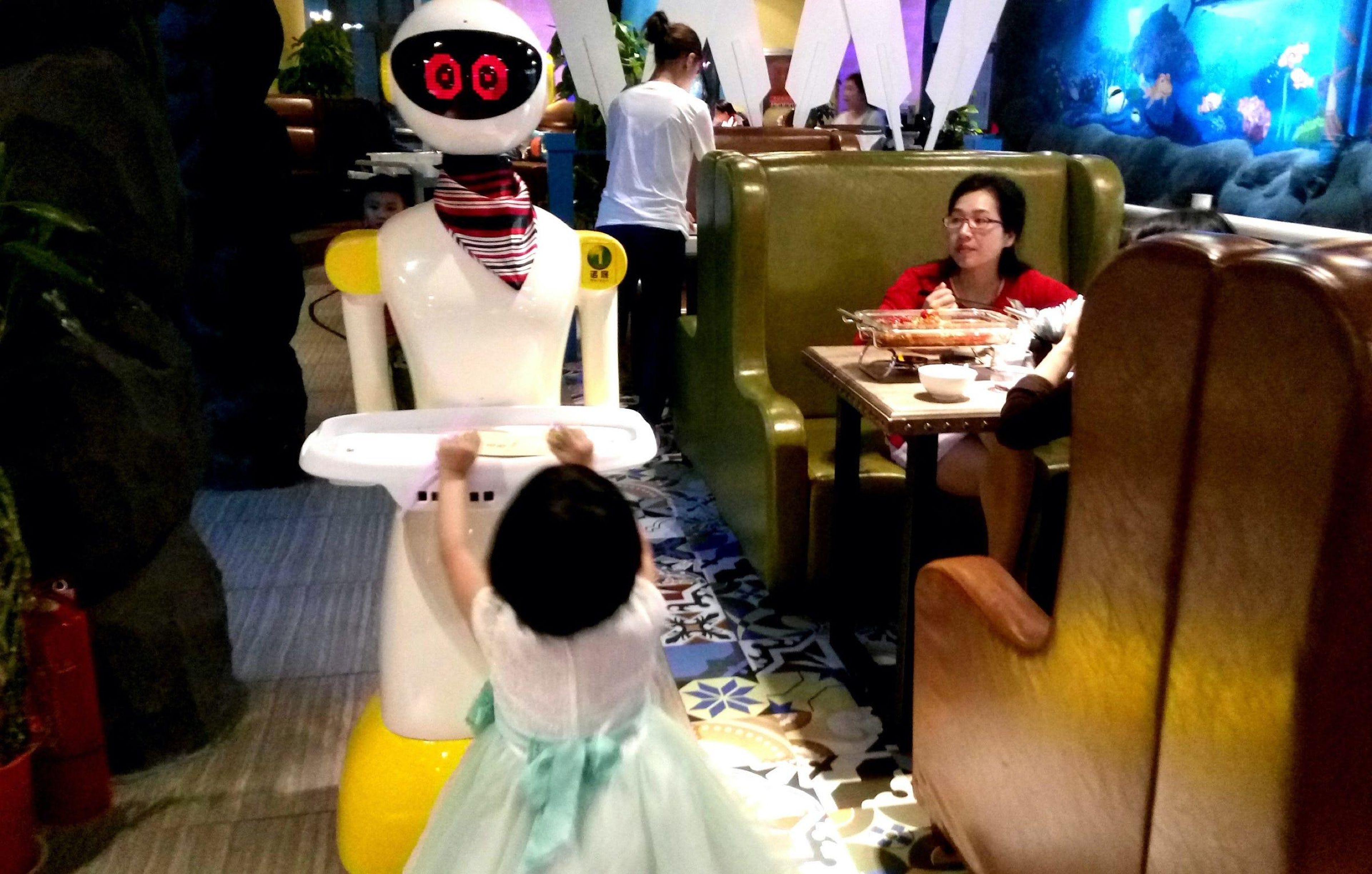 Un robot camarero de un restaurante en Wuhan, China, tiene ojos expresivos en una pantalla LED.