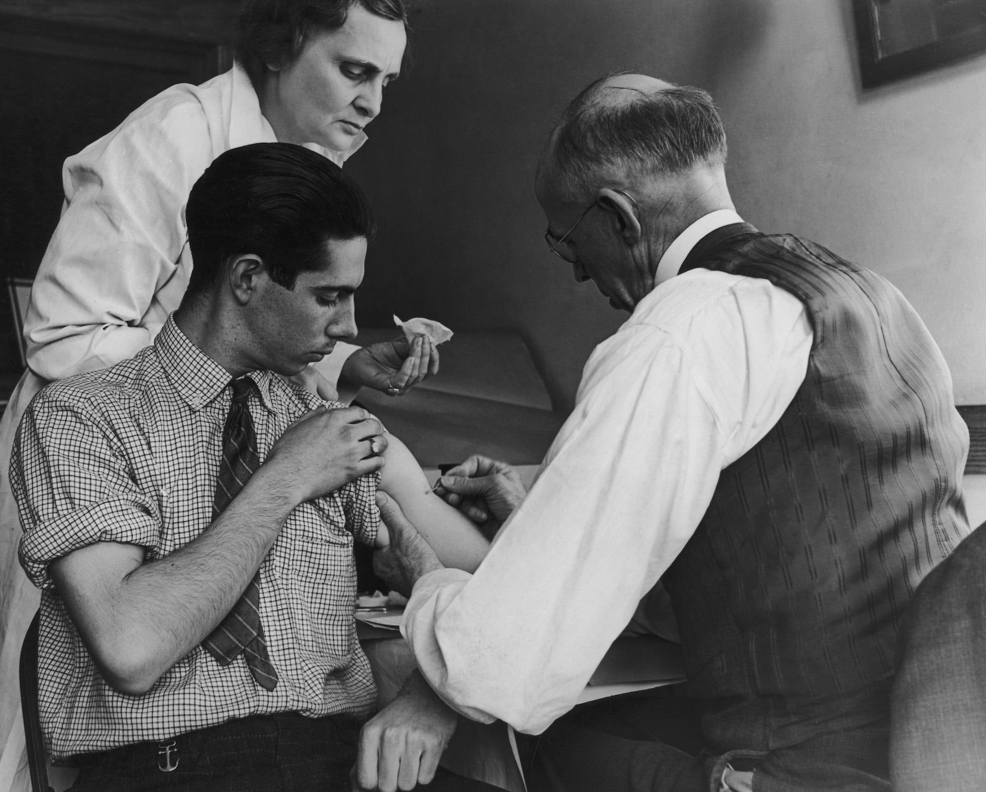 Un adolescente es vacunado contra la viruela por un médico escolar y una enfermera en Gasport, Nueva York, el 15 de marzo de 1938.