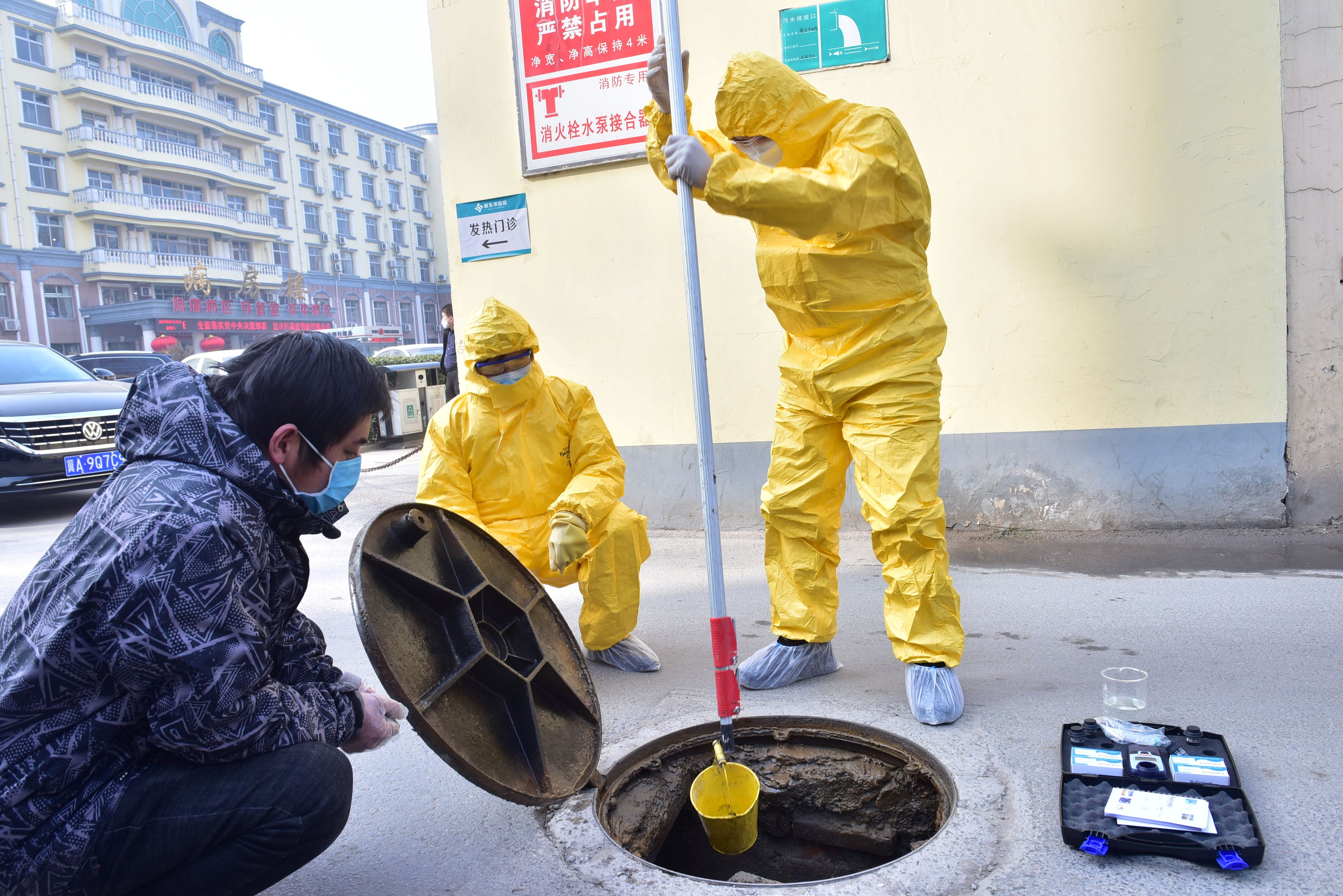 Trabajadores recogen muestras de aguas residuales tras un brote de coronavirus en China.