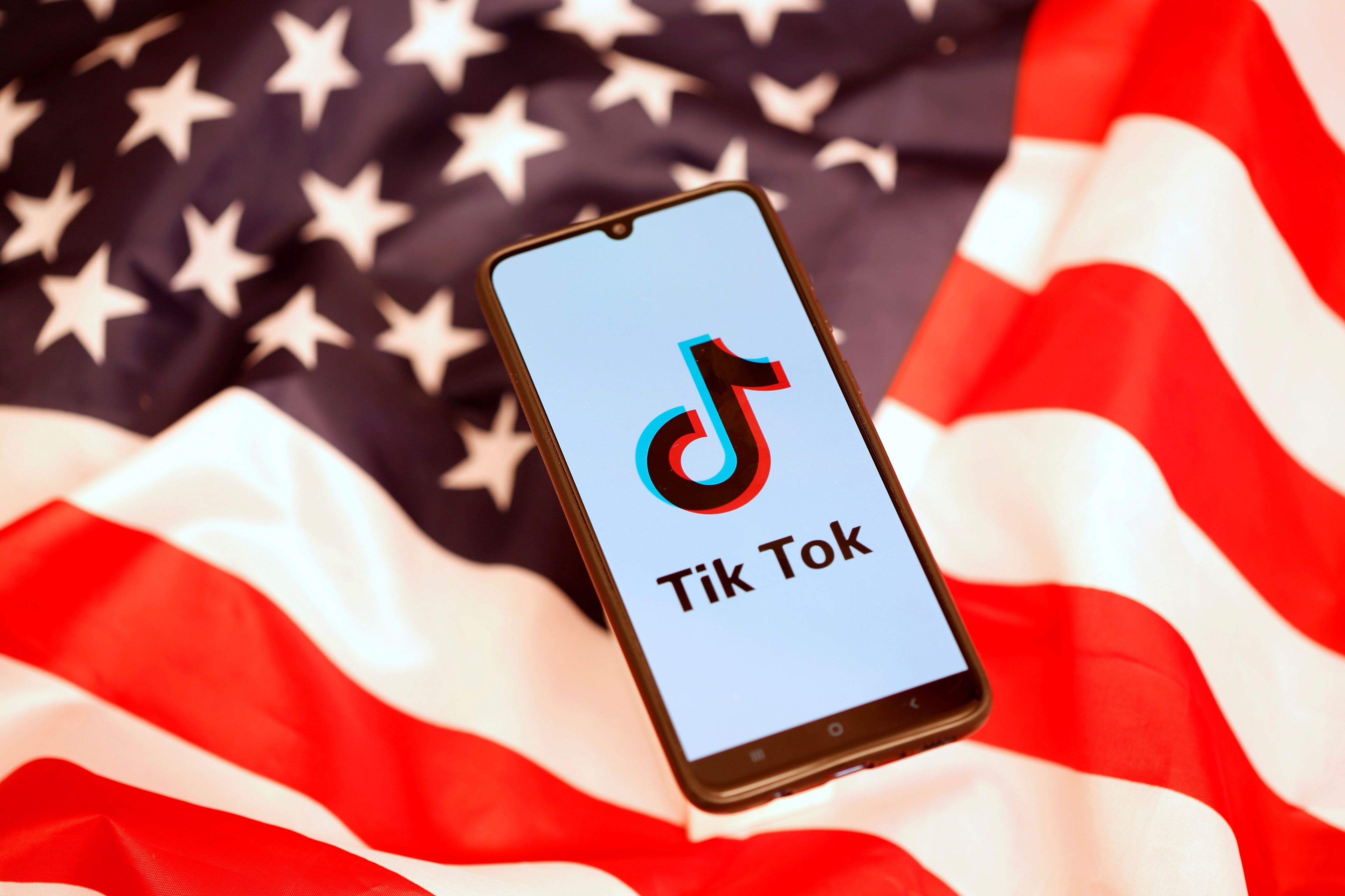 La aplicación de TikTok sobre un fondo con la bandera de Estados Unidos