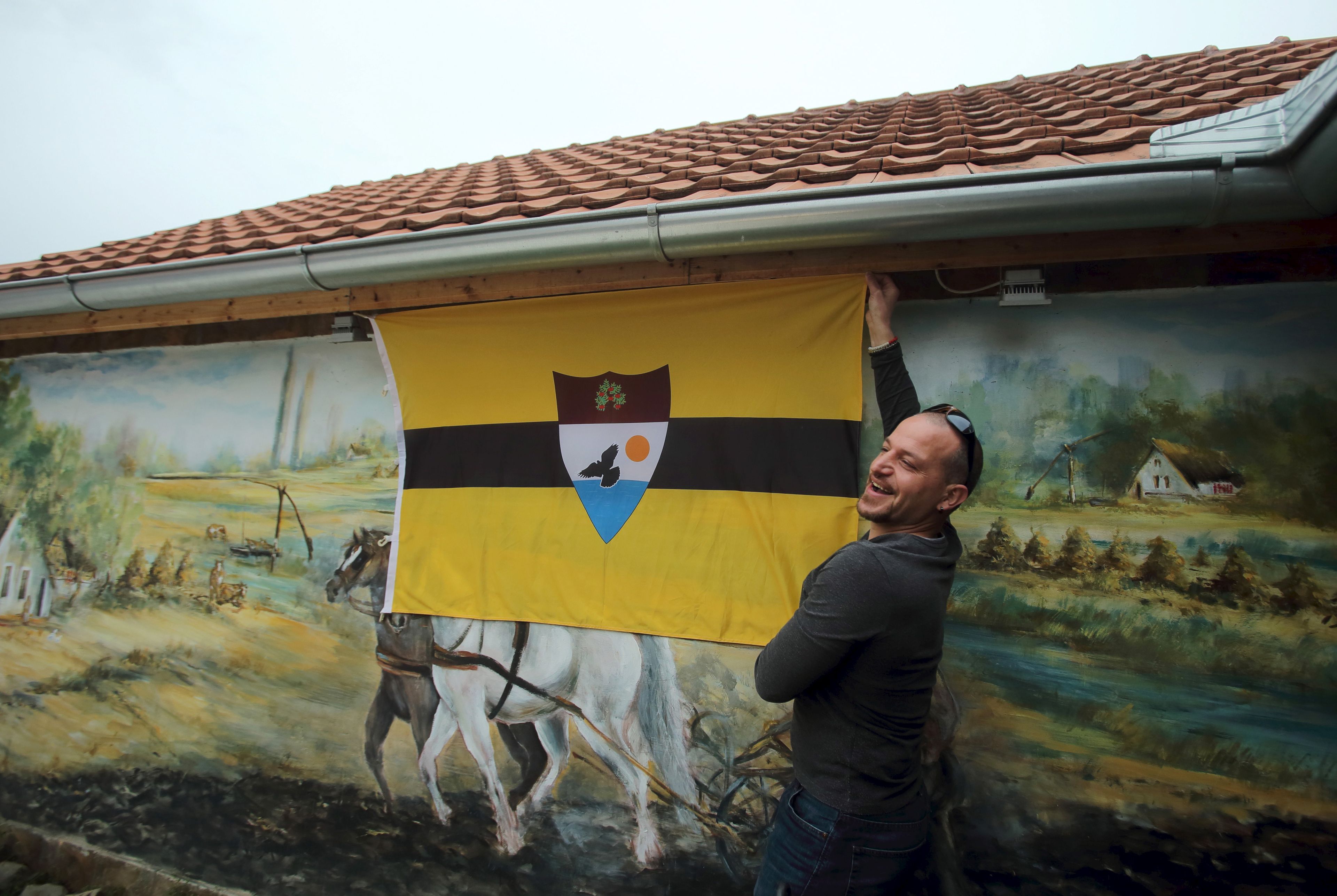 Un hombre muestra la bandera de Liberland en la aldea de Backi Monostor, Serbia, el 1 de mayo de 2015.