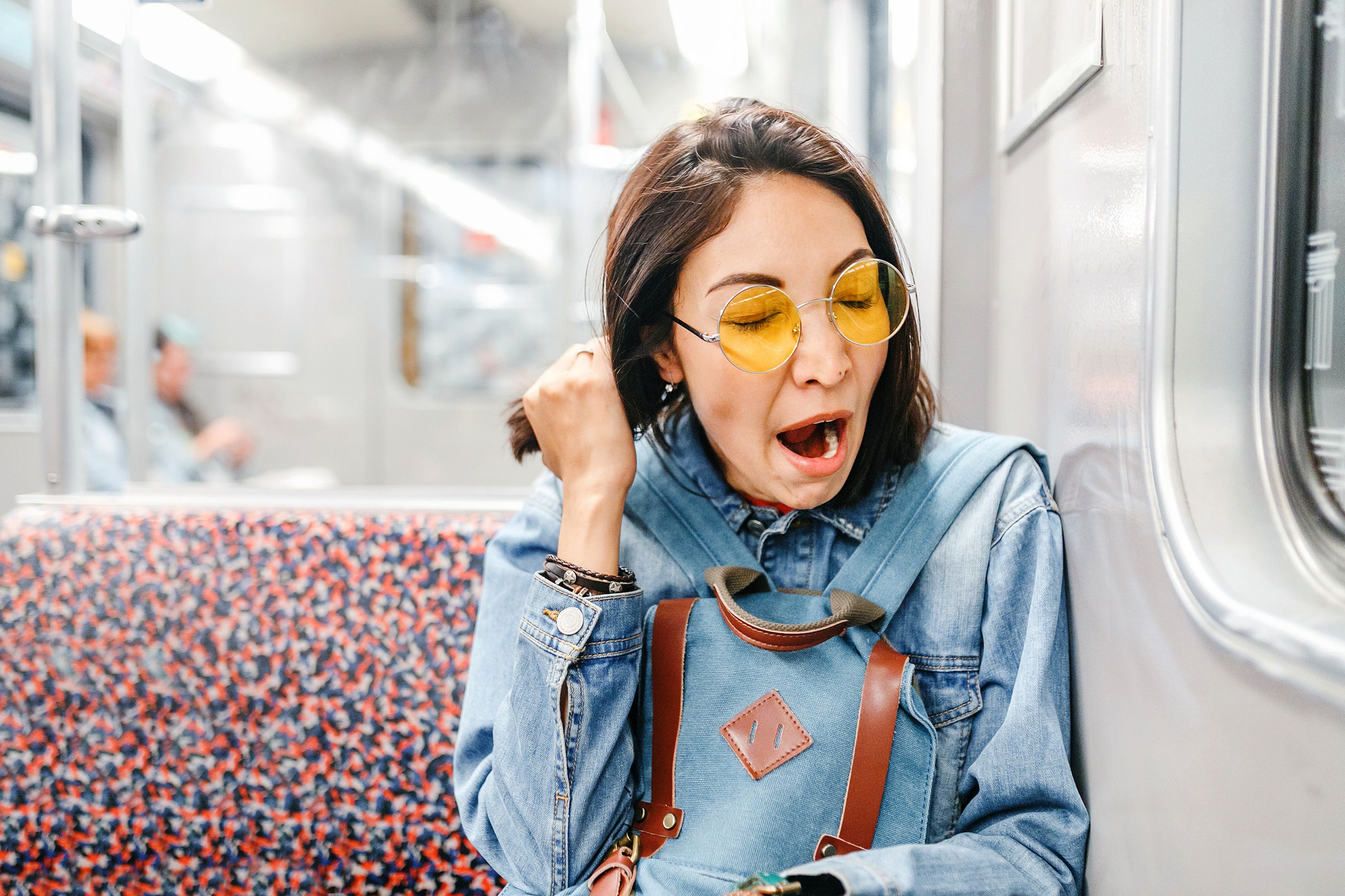 Chica bosteza en el metro.