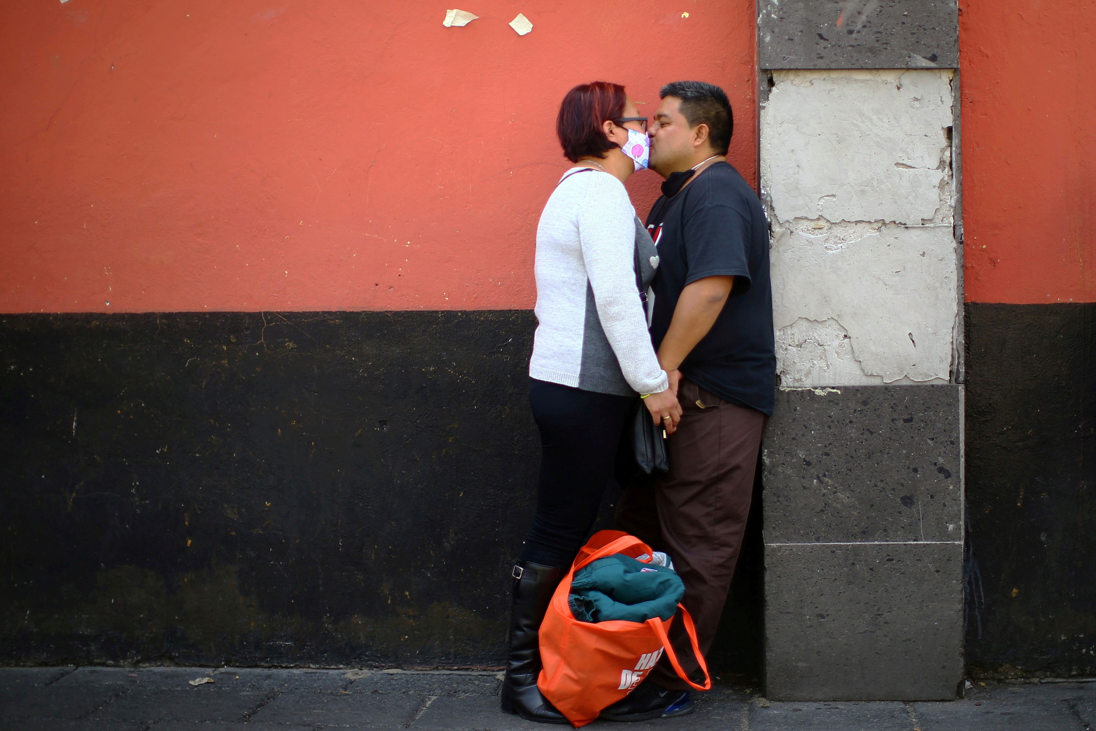 Una mujer con una mascarilla besa a un hombre durante el brote de coronavirus en Xochimilco, Ciudad de México, México, el 6 de agosto de 2020.