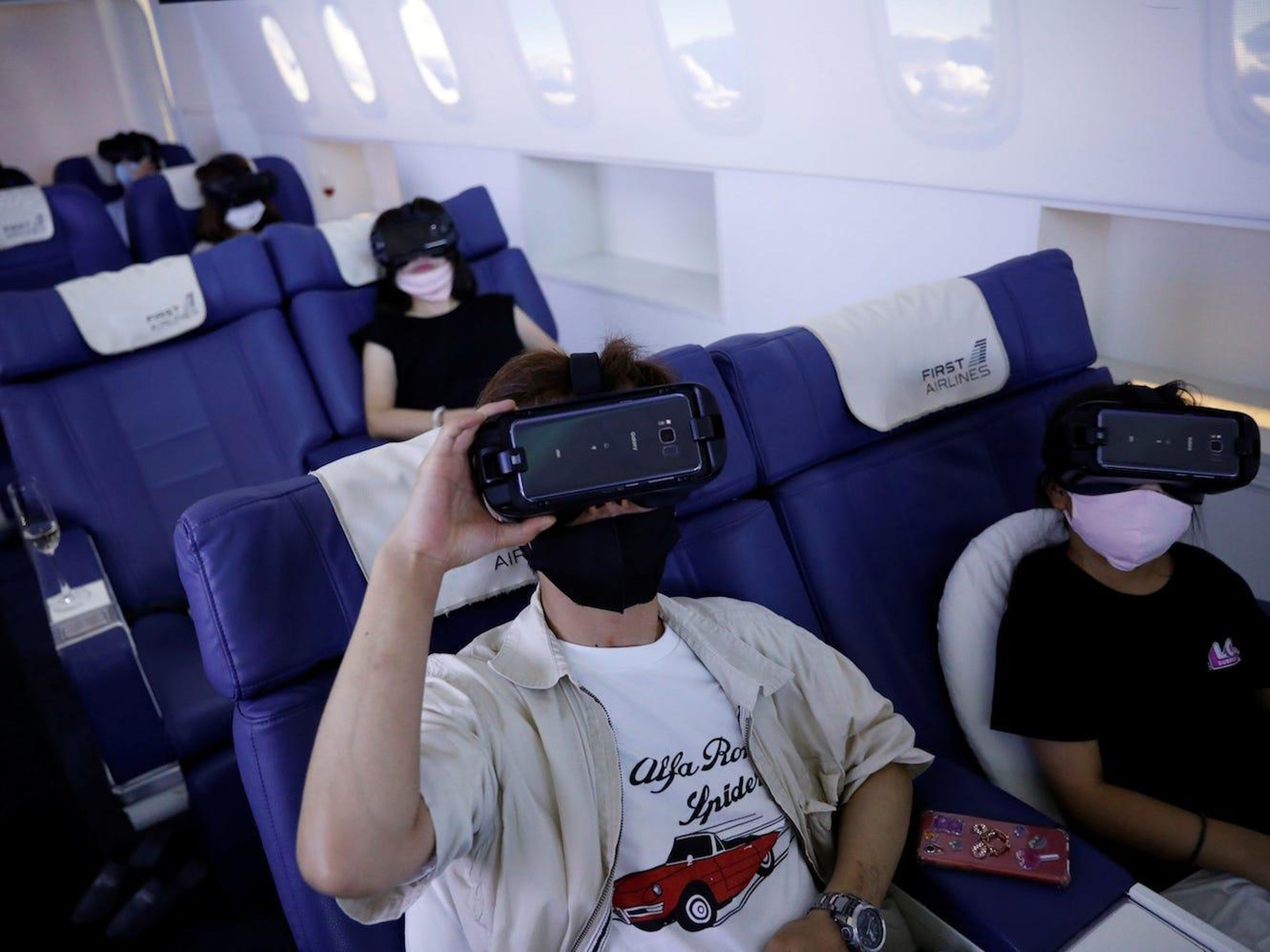 Customers in flight seats use virtual reality (VR) devices at First Airlines, that provides VR flight experiences, including 360-degree tours of cities and meals in Tokyo, Japan, on August 12, 2020. Kim Kyung-Hoon/Reuters