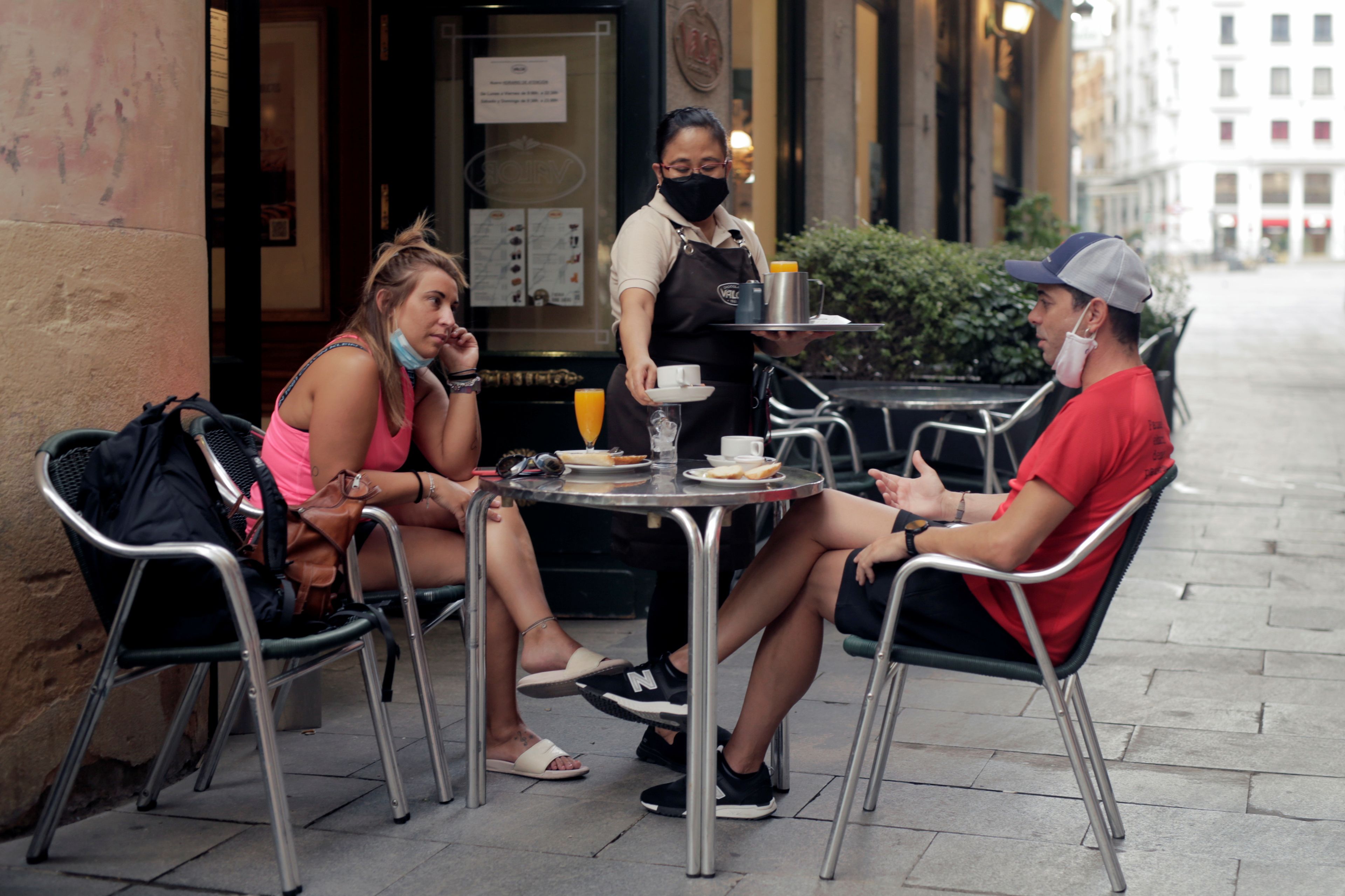 Dos jóvenes tomando algo en una terraza en Madrid.