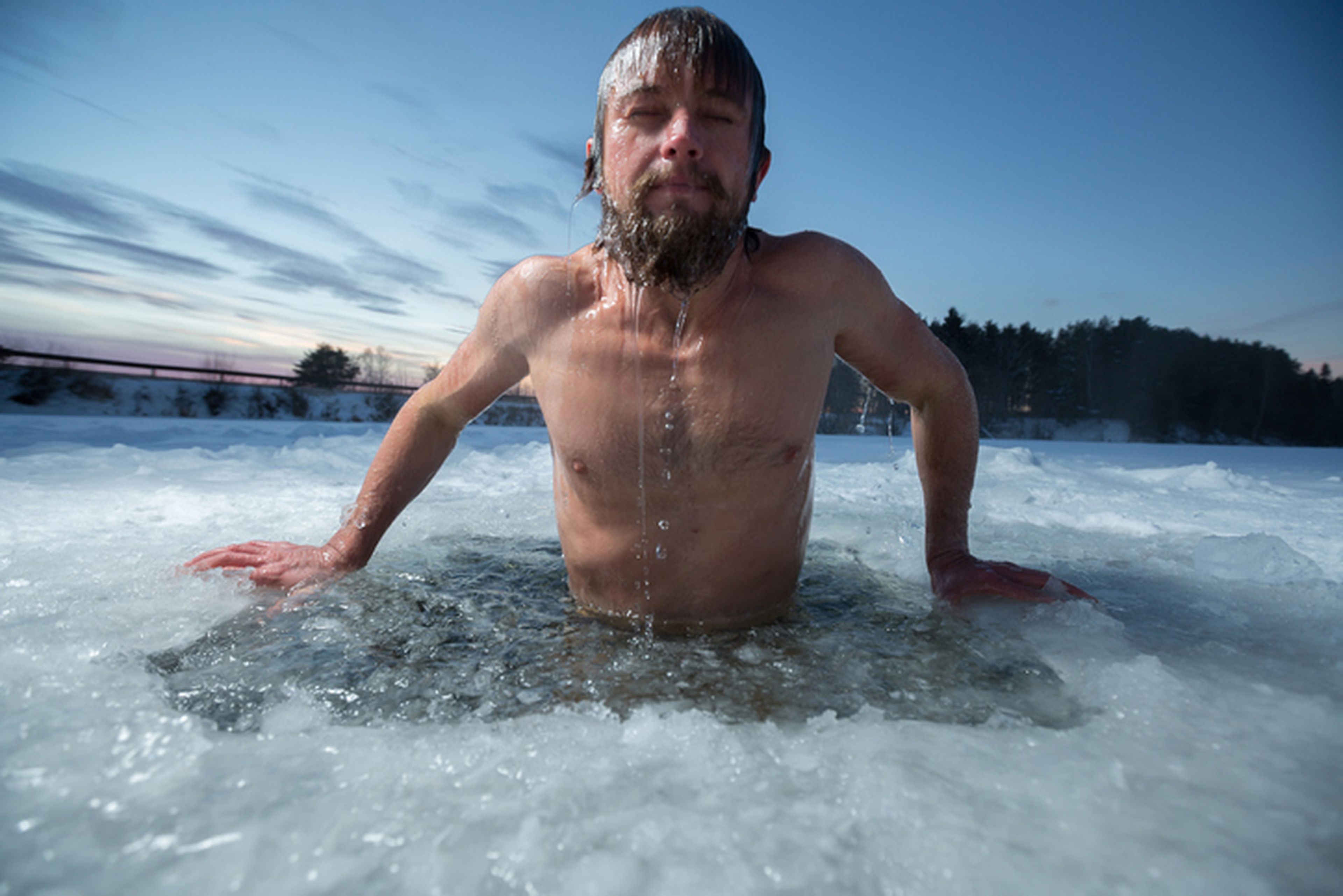 Hombre bañándose en un lago helado.