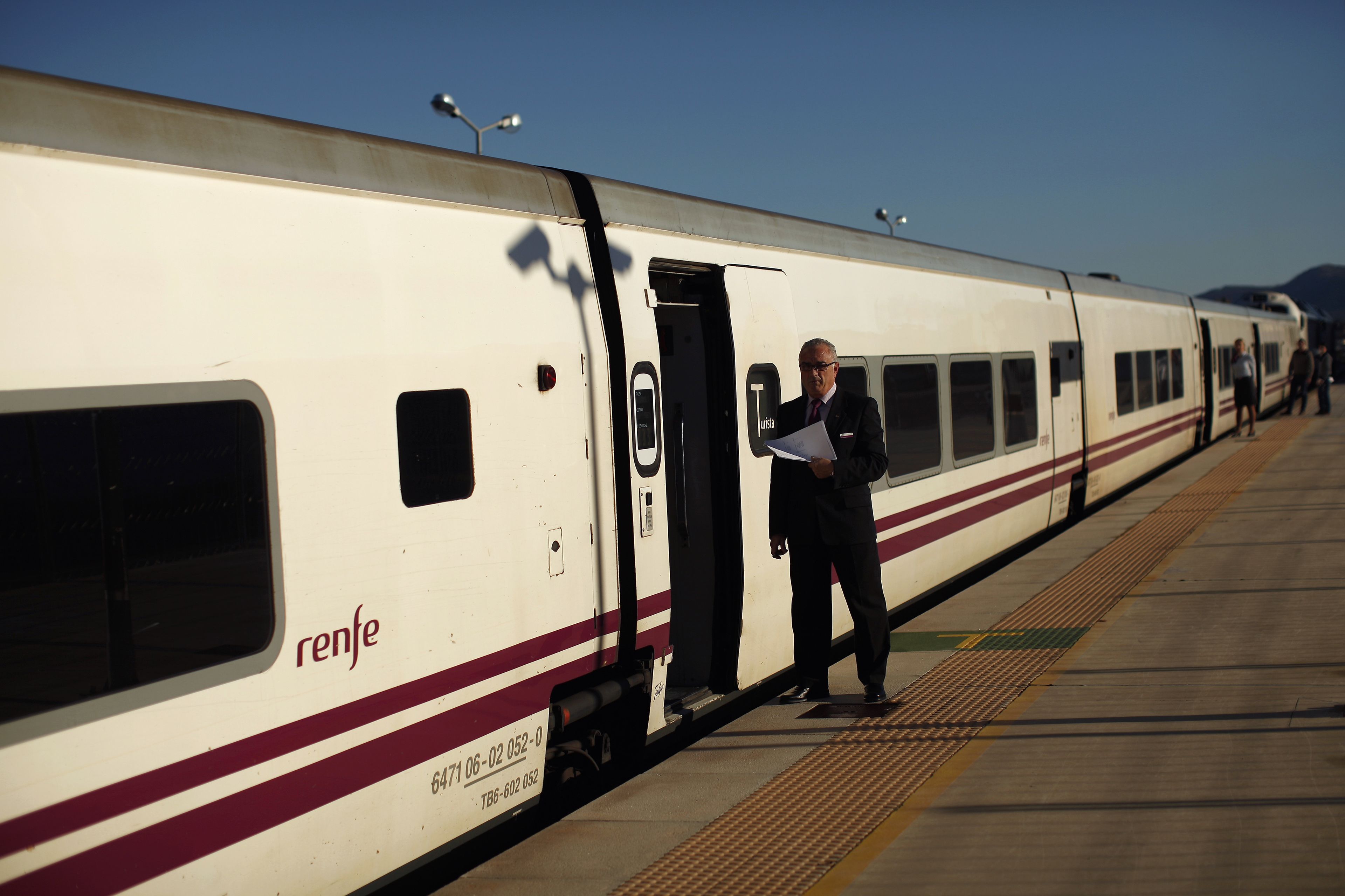 Un trabajador de Renfe espera a que los viajeros se suban al tren en Ronda, Málaga.
