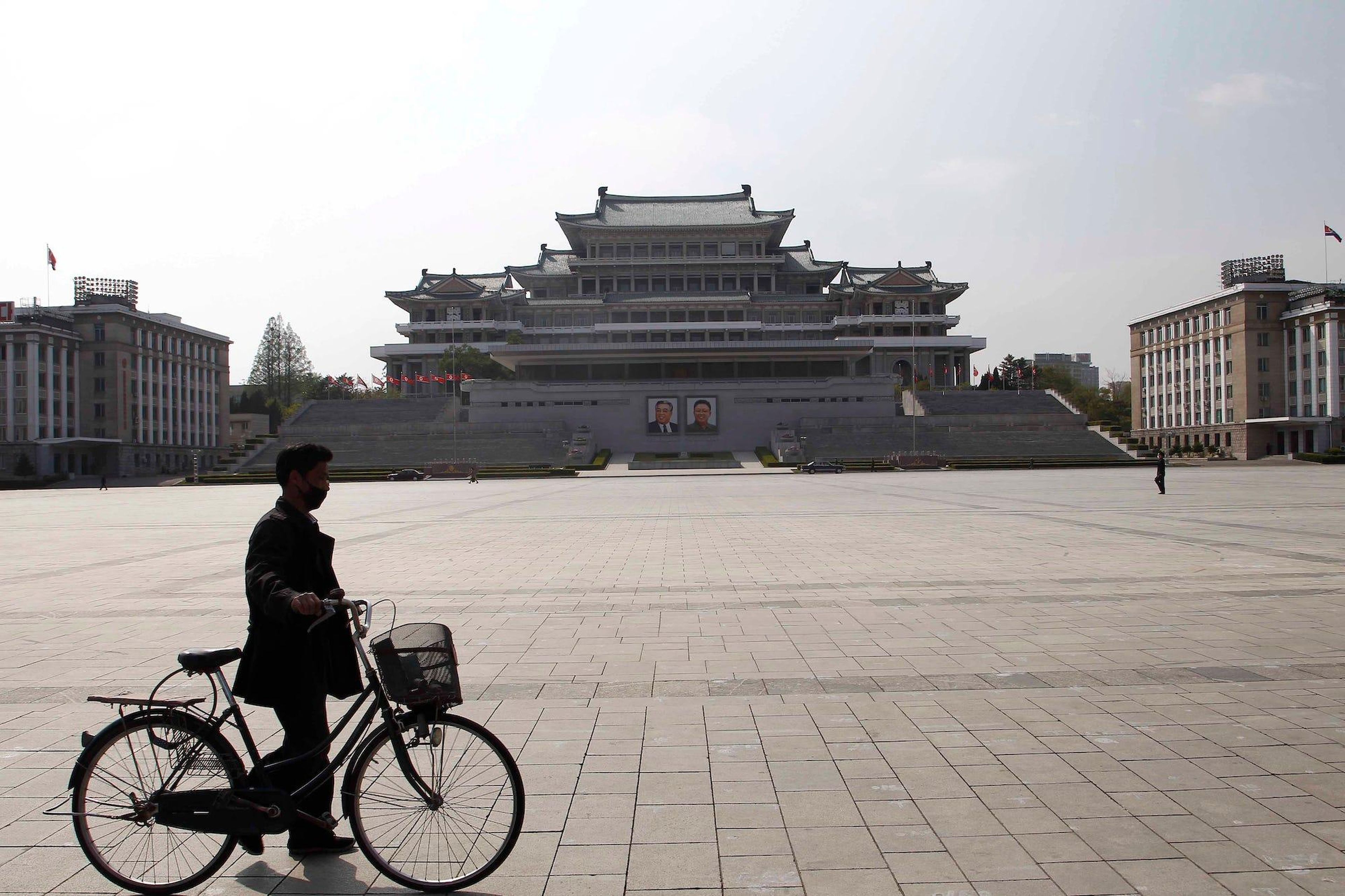 Un hombre camina con su bicicleta en la Plaza Kim Il Sung en Pyongyang, Corea del Norte, en 2020.