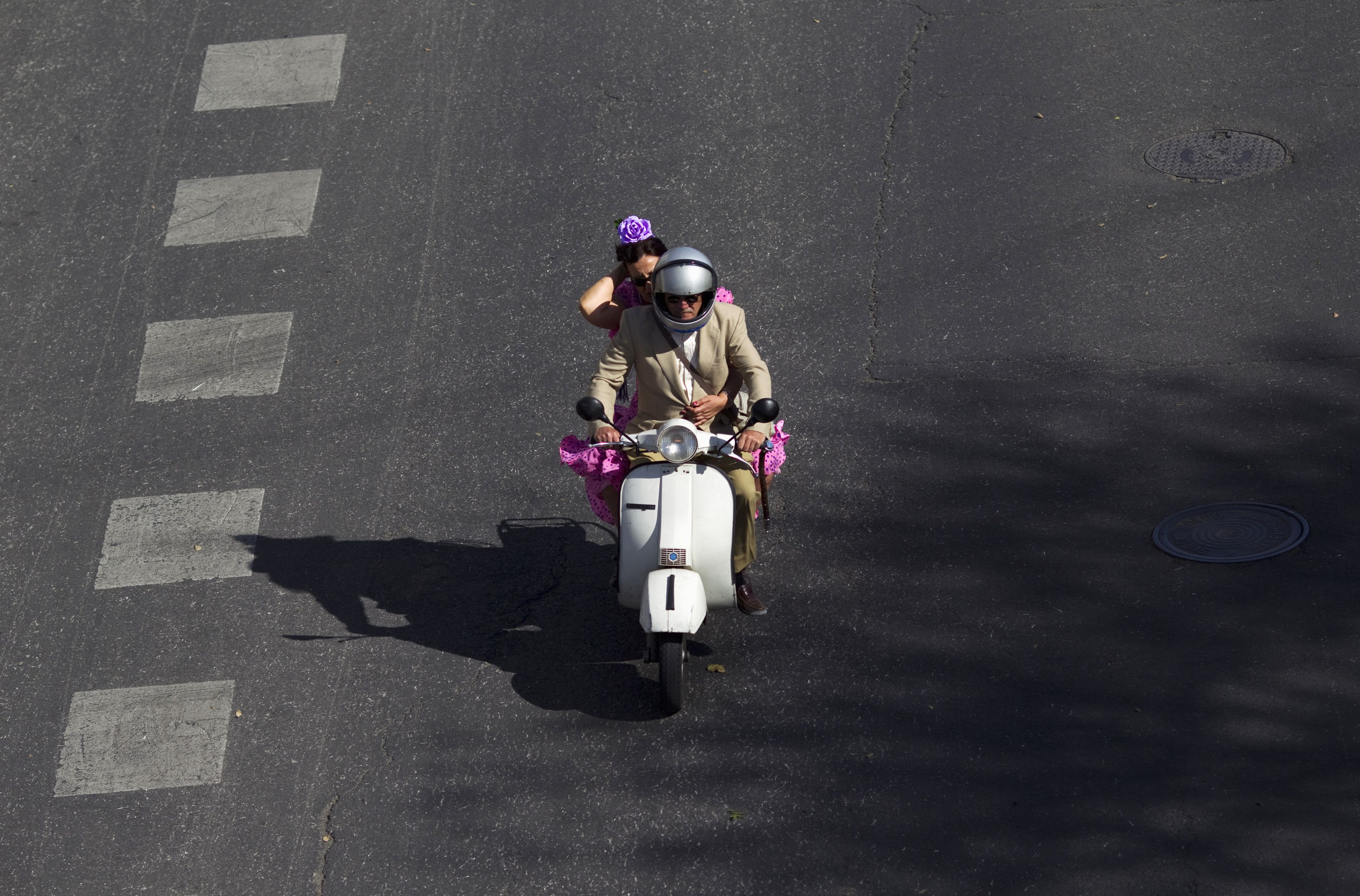 Un hombre y una mujer conducen una moto en Sevilla.
