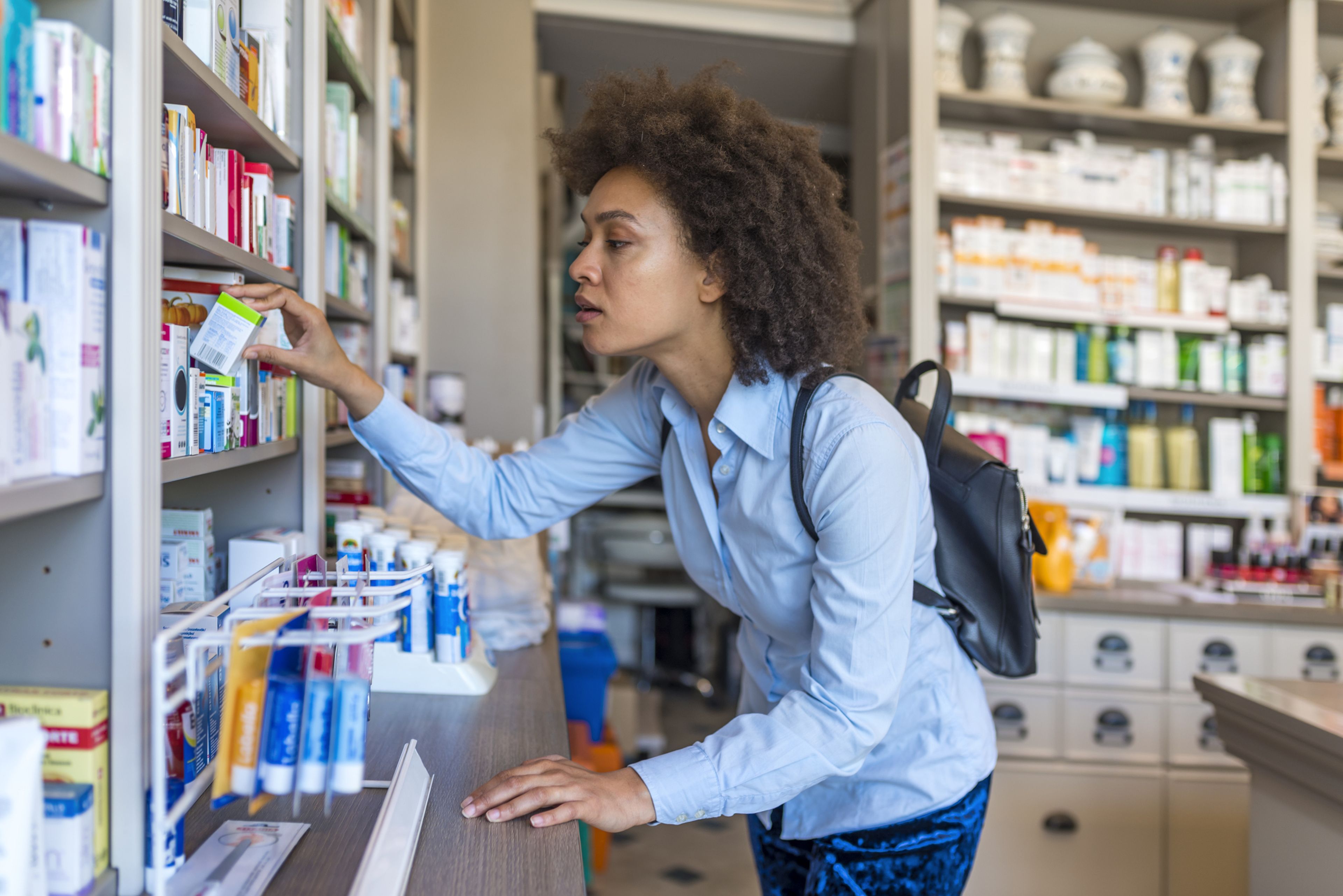 Mujer comprando medicamentos en farmacia