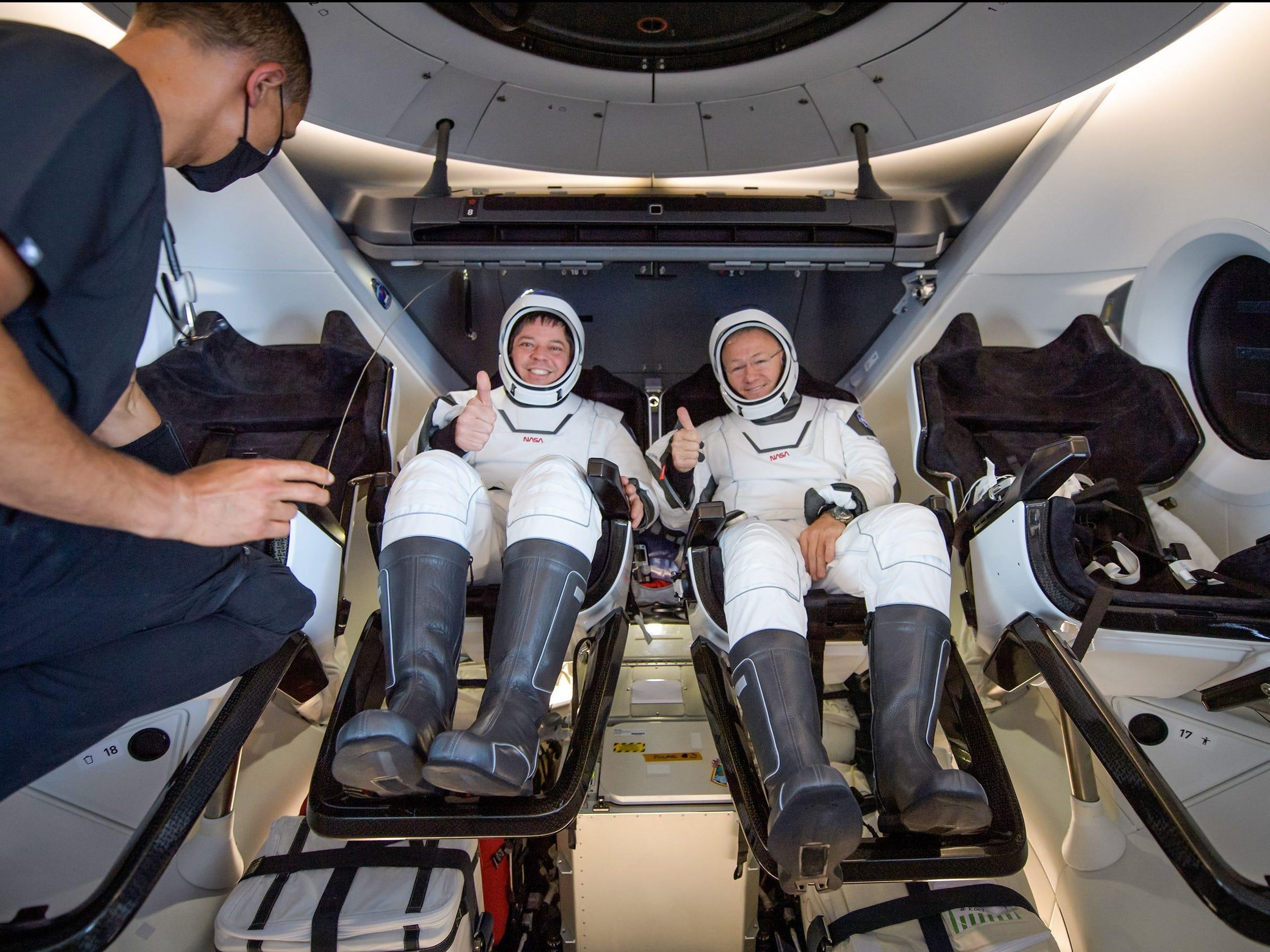 Los astronautas de la NASA Bob Behnken y Doug Hurley dentro de la nave espacial Crew Dragon de SpaceX en la nave de recuperación, poco después de haber salpicado en el Golfo de México cerca de Pensacola, Florida, el domingo