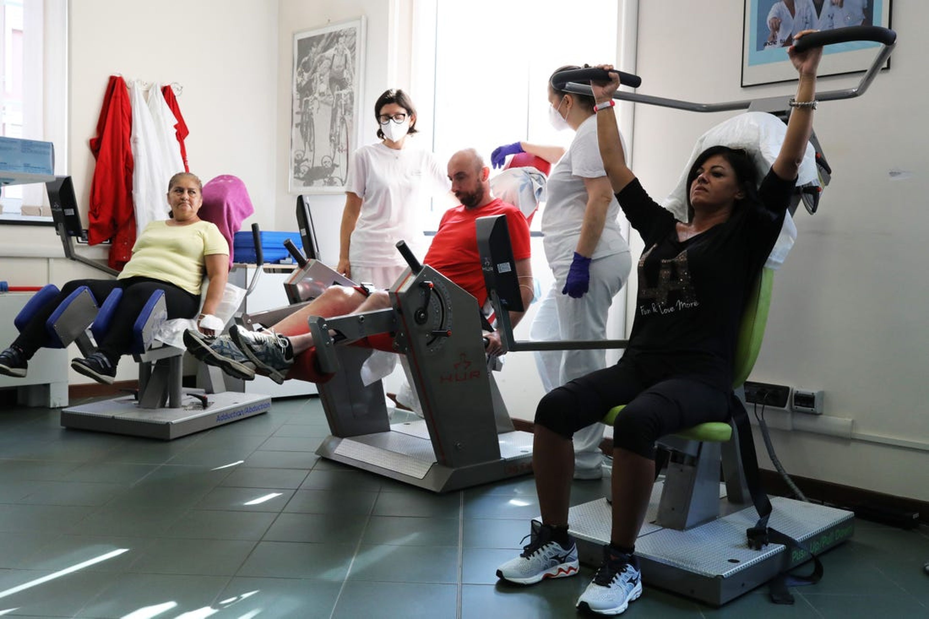 Pacientes de coronavirus en recuperación se entrenan en una máquina para fortalecer el tono muscular en el Departamento de Cardiología de Rehabilitación en Génova, Italia, el 22 de julio de 2020.