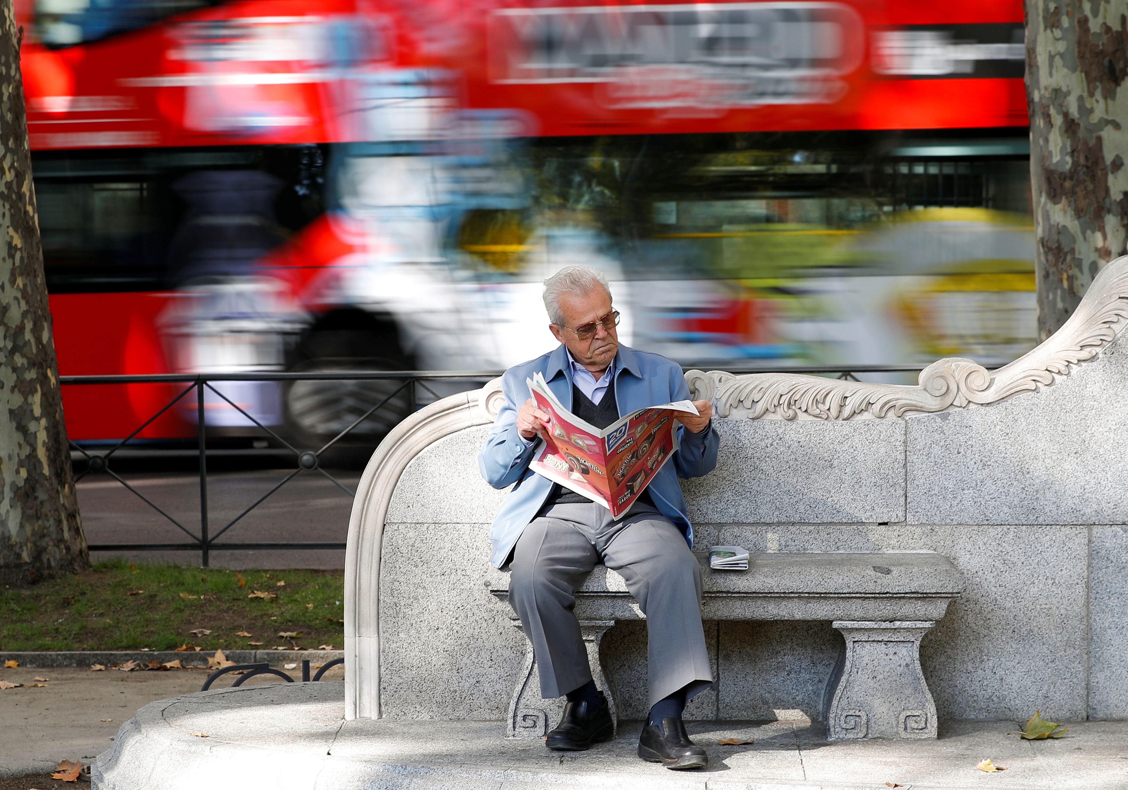 Pensionista lee un periódico en Madrid