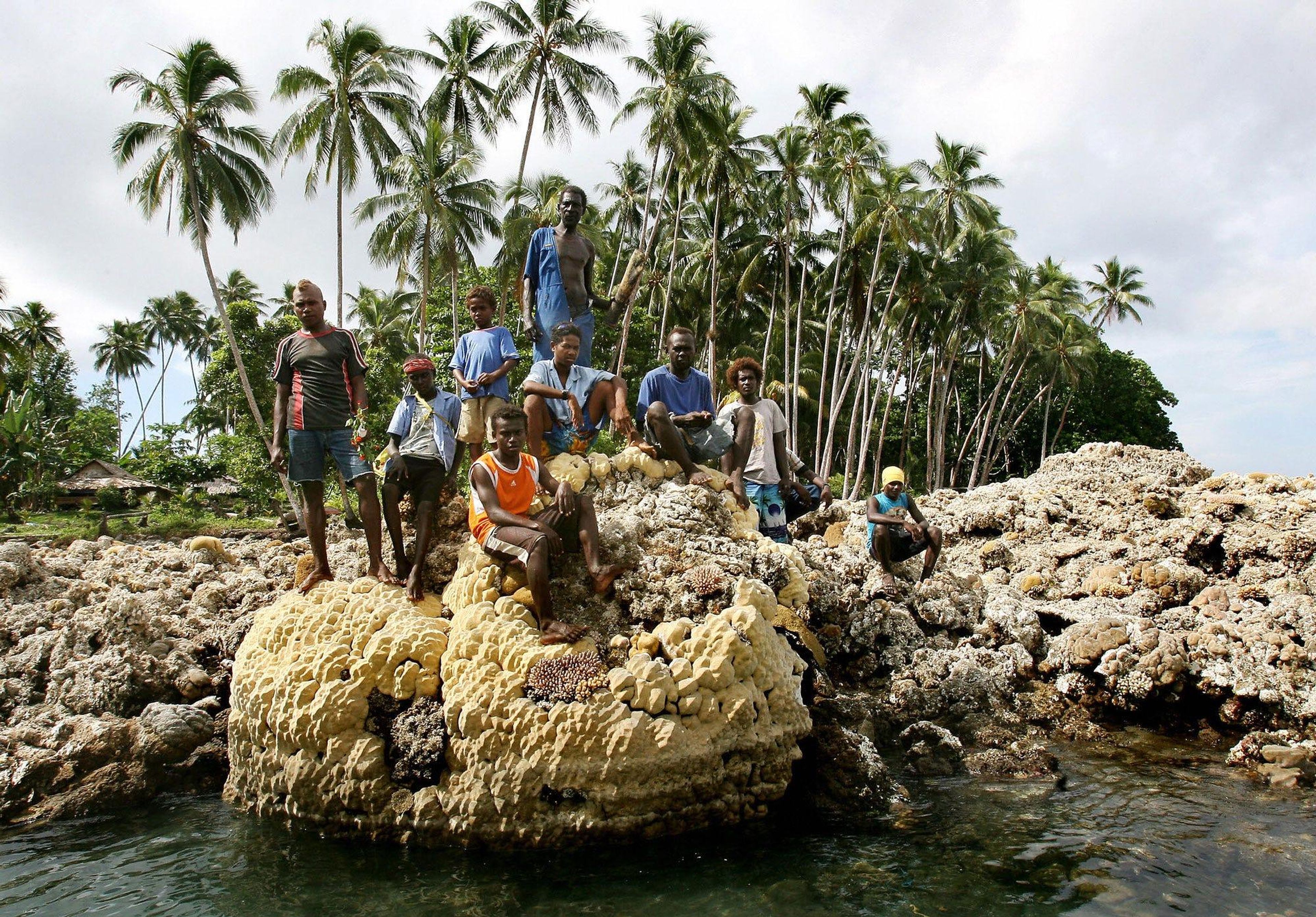Gente sentada en un arrecife de coral en la isla Salomón de Ranongga en 2007.